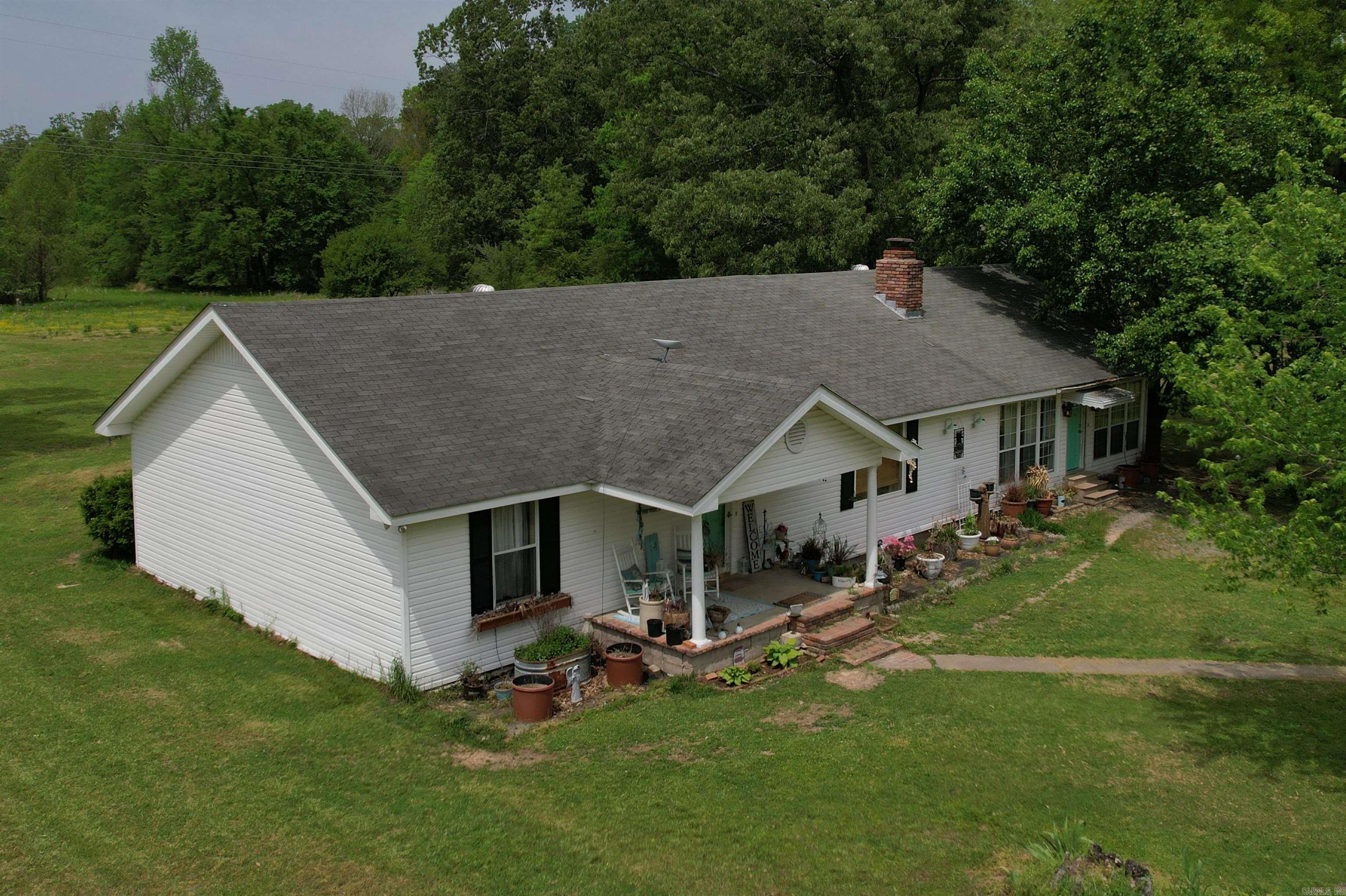 Beautiful, spacious updated house on 5.6 acres! Seller is offering a BUYER CREDIT of $11,000 or seller will install a NEW ROOF! In the country, but only 6 miles to interstate 530, near Glendale, located in the New Home community. Star City school district. House has been updated with newer appliances, vinyl plank flooring, and more. Extra large living room with wood burning and gas logs fireplace, large kitchen with lots of cabinets and a pantry, sunroom, 3 bedrooms are together, a hallway bathroom, and a primary bathroom, large laundry room, 2 car carport, and an outbuilding with chicken coup! HVAC new in 2024. Refrigerator, washer, & dryer stay.