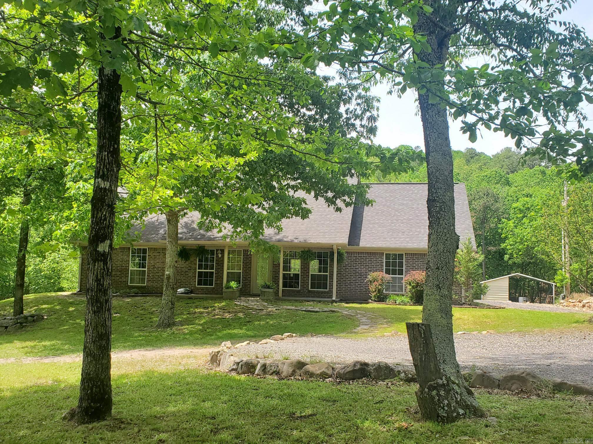 Escape to your own private haven just seconds from Mena! This charming 3-bedroom, 2-bath brick home sits on 27+ beautiful wooded acres with creek at the edge of Mena, offering the perfect balance of seclusion and convenience. Inside, you will love the open-concept layout with a split floor plan for added privacy. Stay comfortable year-round with central heat and air, plus a cozy pellet stove for those cooler days. Step outside and enjoy the natural surroundings from your rock patio, perfect for relaxing or entertaining. A double carport provides covered parking, and the storage building offers plenty of space for tools, toys, or projects. Plus, another portable carport. Home wired for a generator. Whether you are looking for a quiet retreat, a place to explore nature, or a family home with room to grow, this property delivers! Do not miss this one-of-a-kind opportunity — schedule your showing today!
