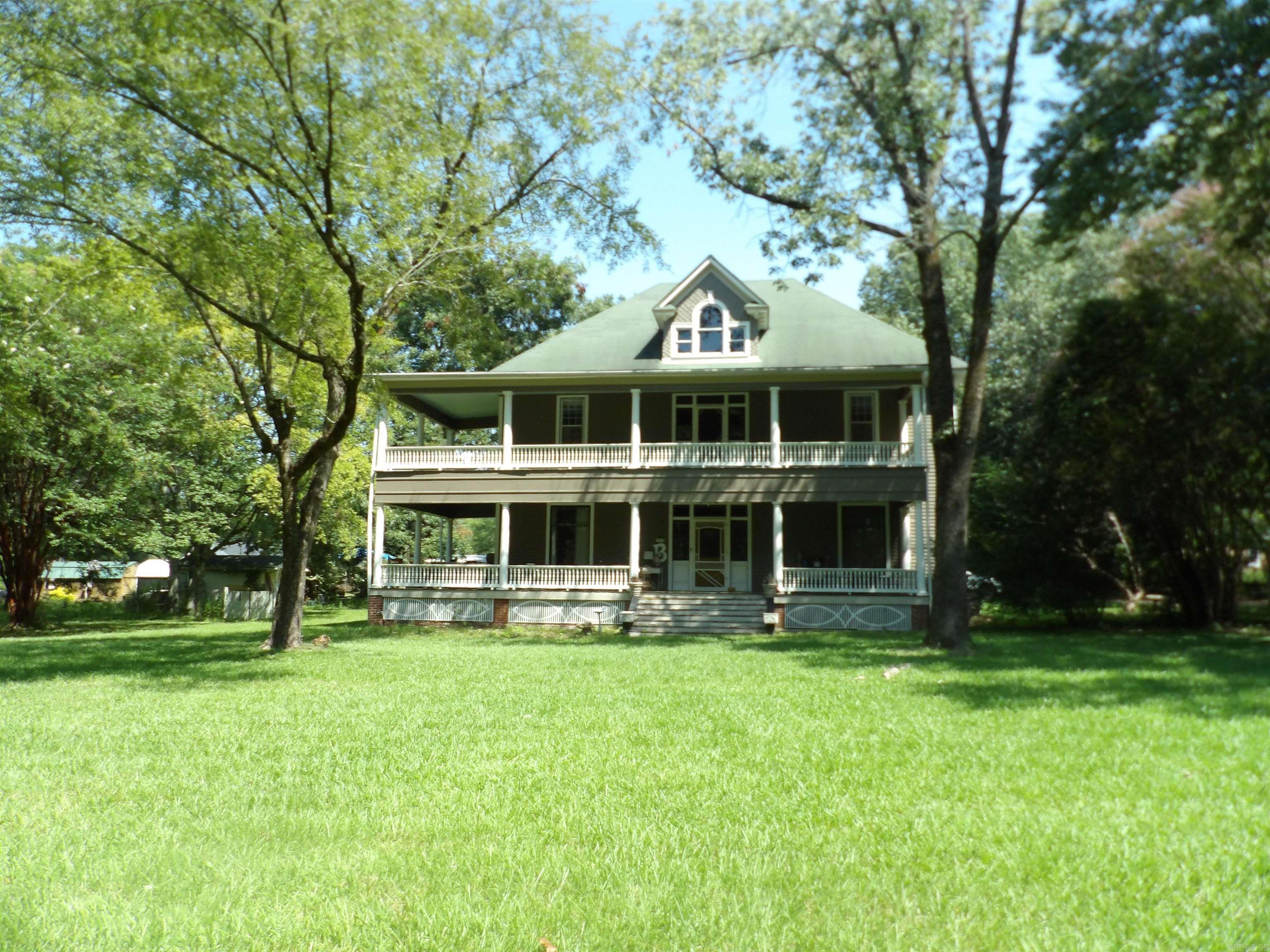PRICE REDUCED on this gorgeous home with a history in town & over 2.6 acres! Built in 1896 & has only had 6 owners. Electric & plumbing have been updated; some within the past 6 years. Roof replaced 1993 & piers in crawl space added for more support. Painted wood floors. 4 gas fireplaces with beautiful mantels. 12' ceilings downstairs, 10' ceilings upstairs. Newer windows. Remodeled bathrooms, the hub of this beauty is the remodeled, updated kitchen featuring granite countertops, gas stove with milled woodwork to match the fireplace mantel; everything done preserving the original integrity of the home. A downstairs room, currently used as a work area, could be the 5th bedroom with its own bath. A gorgeous "parlor" with stunning molding, pocket doors, wood floors & fireplace will be a warm welcome to your family & guests. Another room across the hall is used for dining and entertaining. Gorgeous staircase leads you upstairs to the wide common area and opens to upstairs balcony. 3 spacious bedrooms and bath will serve your family well. Beautiful architecture and abundant storage can be found throughout this home. This is a must-see. Call for appointment today!