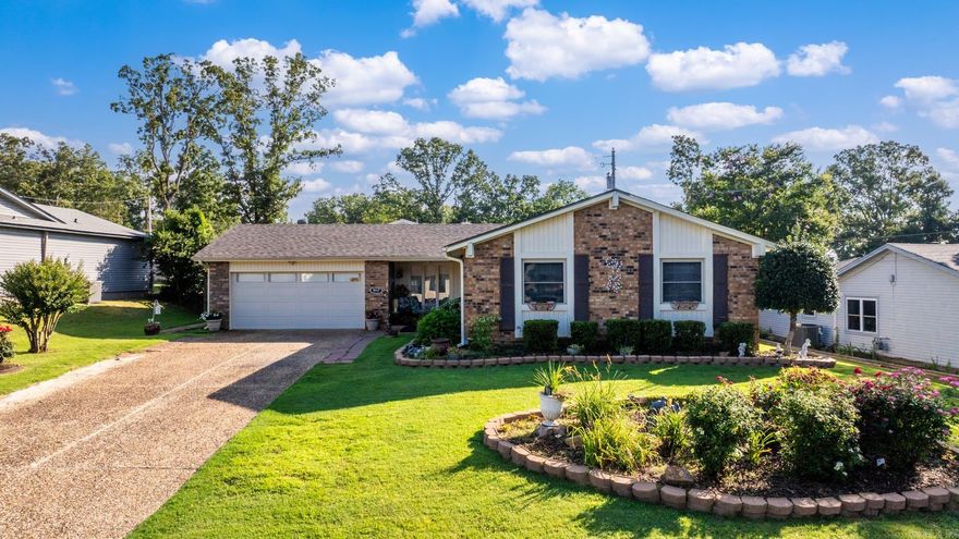 Beautifully updated brick home with incredible indoor & outdoor features in sought after Indian Hills Subdivision!Enjoy a maintenance-free exterior w/gorgeous landscaping,shutters,gutters,oversized driveway & a new roof (2023).The front porch welcomes you with a ceiling fan & storm door.Inside you’ll find wide plank handscraped wood laminate floors, a spacious front living area/formal dining w/large triple windows(Detached portable fireplace does not convey) and a cozy den with a corner brick lined gas log fireplace.The kitchen has been fully refreshed in 2023 w/new appliances, sink, faucet & custom cabinetry.The dinette includes a built-in coffee bar & plenty of natural light.Bedrooms are generously sized w/updated flooring, double closets & an updated master bath with a new tiled walk-in shower(2023).Relax or entertain in the large fenced backyard featuring a huge covered patio w/stamped concrete, a covered gazebo, firepit area & a newly built(2023)she-shed/mancave—heated, cooled, and partially finished w/extra storage.The attached 2-car garage offers bonus space & a storage room and can easily be converted back if needed. Convenient location, move-in ready with so much to offer