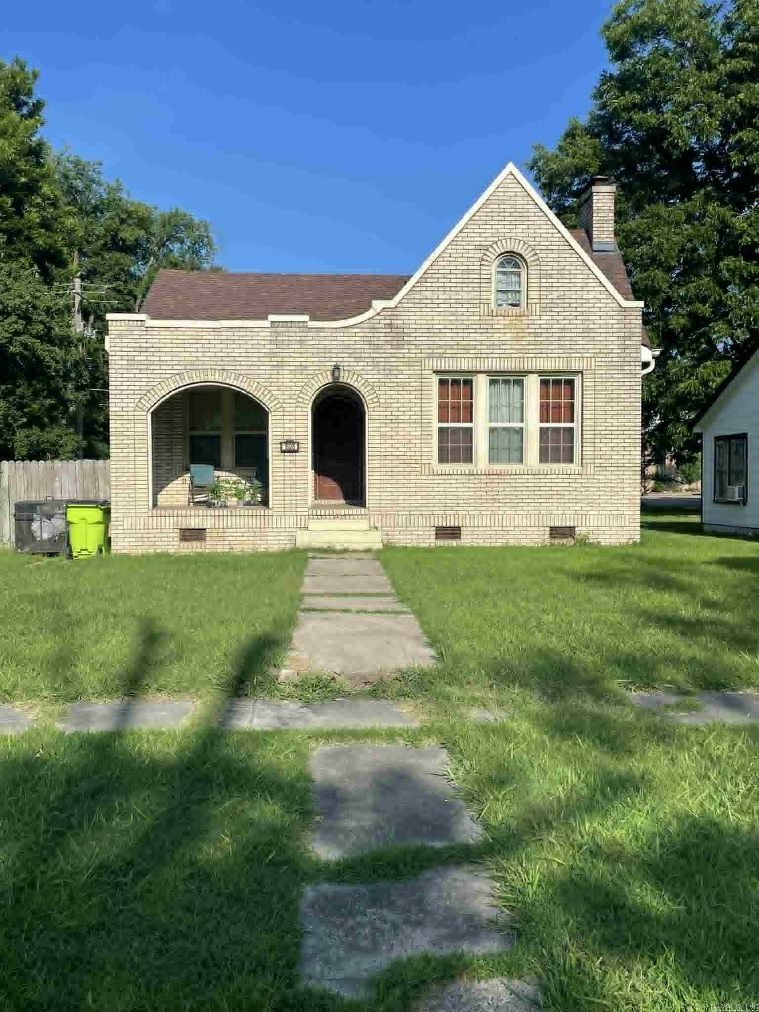 Charming Tudor Revival brick home just minutes from downtown Stuttgart! This 4-bedroom, 2-bath, 2-story home offers 2,020 sq ft of character and comfort. Featuring a steep gabled roof, arched entry, and detailed brickwork, it blends timeless curb appeal with a spacious interior. Enjoy generously sized rooms, a functional layout, and a prime in-town location close to schools, shopping, and dining. A rare find full of personality and potential!
