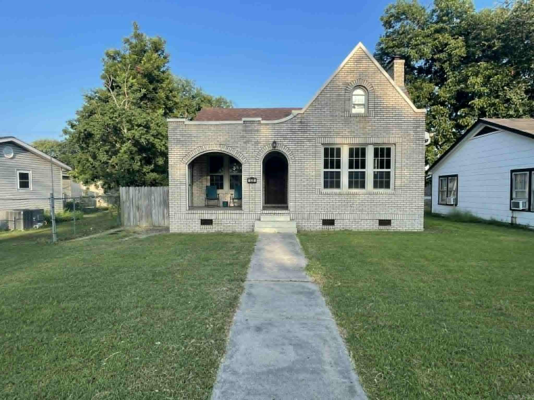 Charming Tudor Revival brick home just minutes from downtown Stuttgart! This 4-bedroom, 2-bath, 2-story home offers 2,020 sq ft of character and comfort. Featuring a steep gabled roof, arched entry, and detailed brickwork, it blends timeless curb appeal with a spacious interior. Enjoy generously sized rooms, a functional layout, and a prime in-town location close to schools, shopping, and dining. A rare find full of personality and potential!