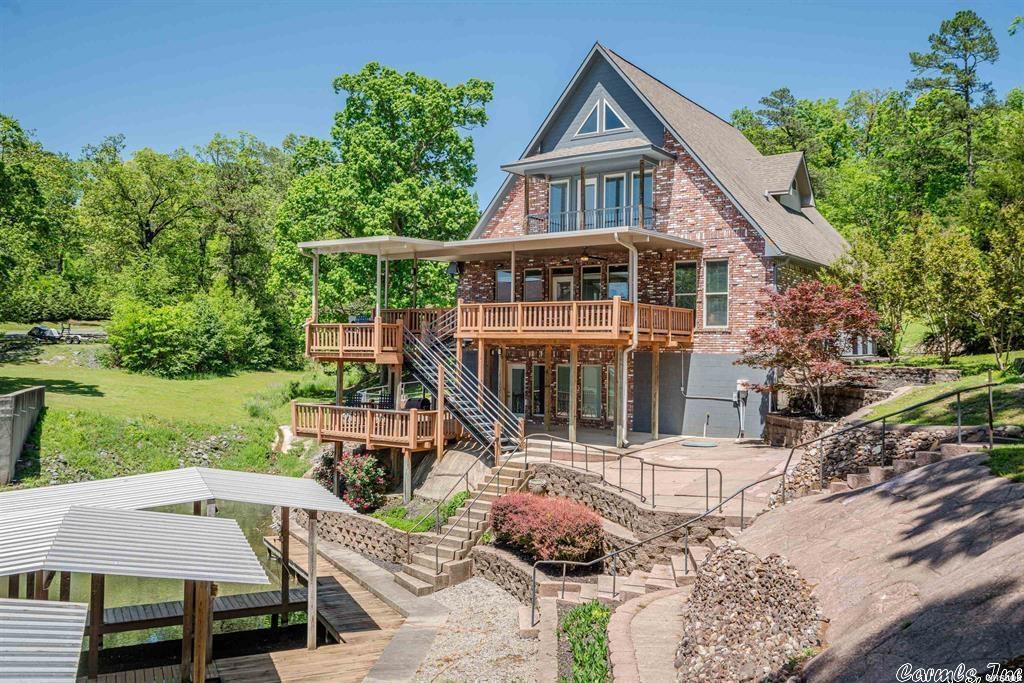 Welcome to this BEAUTIFUL builder owned SPACIOUS custom-built home. NOTE: added a boat dock & extra lot. Property comes with two boat slips. Current active STR permit in place. Upon entering take in the lake views from the floor to ceiling windows. Home come fully furnished & just steps away from the lake. This unique property features two master suites on 2nd floor, two large bedrooms on main level floor and one large BONUS room downstairs that is currently used as a bedroom and boasting a large bathroom