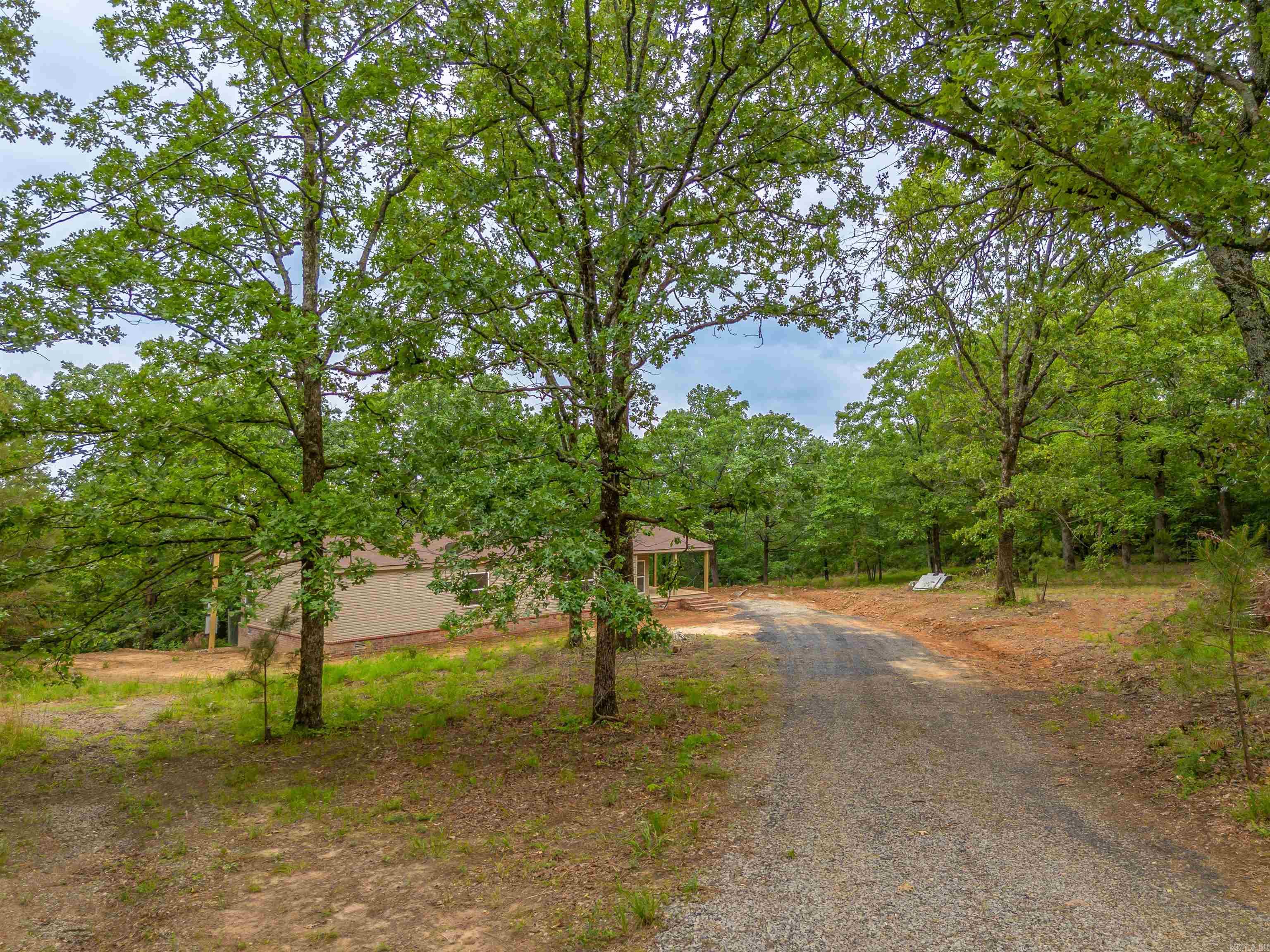 Check out this beautifully remodeled doublewide home situated on 5 secluded acres outside city limits with no restrictions. Luxury vinyl floors throughout the home with a wood burning fireplace that has a cedar wood beam above the FP in the living room The kitchen features granite countertops, subway tile, and beautiful centered island with ample space to have a dedicated coffee bar. Large primary suite with shower, soaking tub and walk-in closet. Almost everything in this home is brand new: Roof (2023), HVAC (2025), HWH (2025), New Appliances, Barn Doors in master, from the floor to the ceiling is new throughout. Exterior has new windows, new siding, new facia, new porch, new brick skirting and stairs. Permanent Foundation approved for VA, FHA, and RD Financing. Storm Shelter on site. Great location with easy access to the back gate at Little Rock Air Force Base. Easy drive to Conway, Cabot, and the Little Rock metro. Lets get you pre-approved and into this beautiful home.