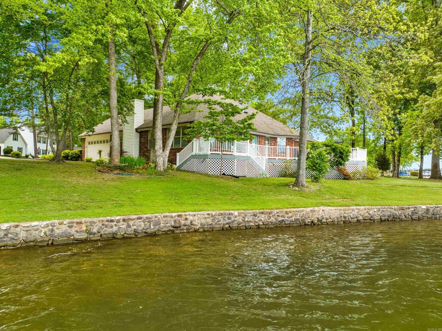 Prepare to fall in love with this stunning Lake Hamilton home, nestled within the prestigious "Lakesouth Estates" gated subdivision. This half-acre, level property checks every lake-lover's box - including 170-feet of pristine shoreline and year-round, deep water access. Step inside the home to discover gleaming hardwood floors gracing the main living areas, creating a warm and inviting atmosphere. The open, gourmet kitchen features top-of-the-line Viking appliances and upscale custom cabinets. Unwind in the bright and airy sunroom, a blissful haven bathed in natural light and offering panoramic vistas of the lake. The oversized master suite offers private access to the Sunroom/Deck and a gorgeous walk-in tiled shower. Expansive composite decking stretches across the back of the home, providing the perfect platform for outdoor entertaining, relaxing, or simply soaking up the breathtaking views. Lakesouth Estates Subdivision offers a community boat launch and boat storage. The best lake property in it's price range, this is the perfect place to call "Home".