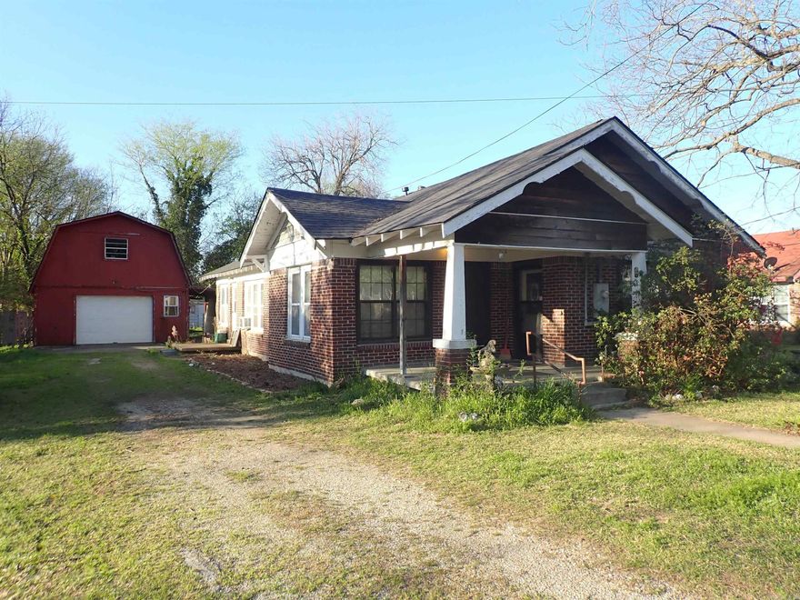ONE-STORY, Dark RED BRICK HOME with painted white trim (frame), MISSION STYLE from the mid-1930's with front porch -and- a DETACHED, 2-Level, Barn- shaped, GARAGE/SHOP (20' x 22') w/stairway to 'room above'.  Plus, this Property has a nice-sized BACK YARD that has been a 'garden area' for years!  The interior of this home has 9' tall ceilings, mostly.  The floor plan features a LIVING room, DINING room, a big KITCHEN with stainless appliances (NEWER Refrigerator/Freezer, a natural gas Range, & sink, and enclosed back porch with LAUNDRY CONNECTIONS, 3 BEDROOMS and 2 BATHROOMS.  The square footage IS JUST RIGHT --- at 1,386 heated/cooled!  Gas space heat/window air conditioners.  This home has BRAND NEW SHINGLES on the roof!  Some repair is needed in different areas of the house (inside and outside).  THAT IS WHY THE PRICE IS ONLY $89,500.00.  Come and see 'what you think'.  New on the market!