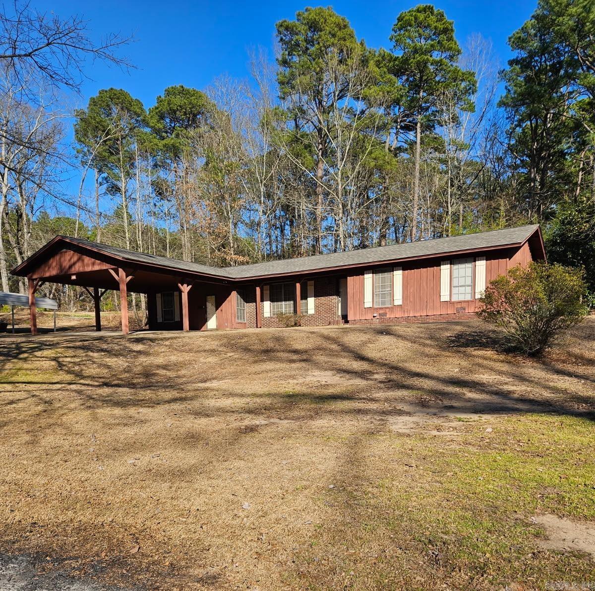 Come take a look at this 3BR/1.5BA cedar with brick home conveniently located to schools, shopping, and more. Eat-in-kitchen with dining room combo. Lots of cabinet space, including a lazy-susan and separate pantry. French doors open to fenced back yard. Beautiful decorative brick FP/non functional (could add gas logs). HUGE bonus room w/storage area provides endless possibilities. Lots of room to park underneath the double carport. BRAND NEW ROOF w/Architectural Shingles and BRAND NEW HOT WATER HEATER! Outside storage area with lean-to. Nice yard- Call today!