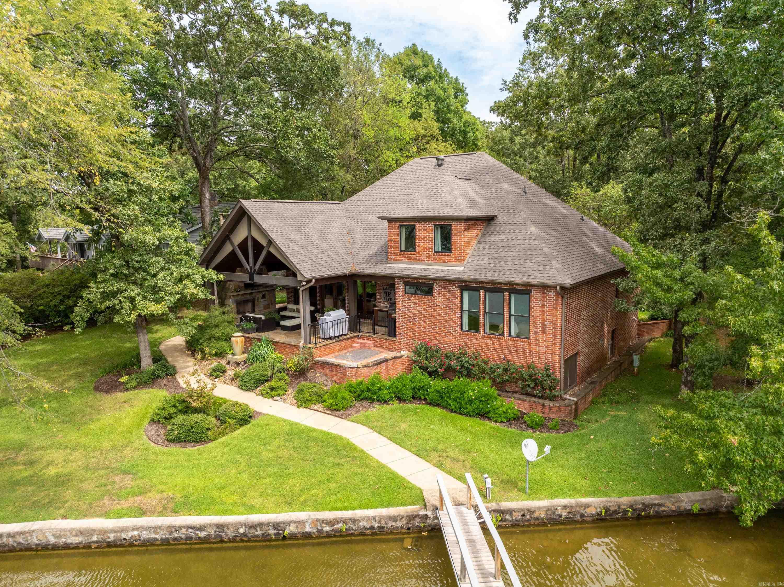Charming Lake Hamilton Retreat on Bayshore Drive: Welcome to 480 Bayshore Drive, a picturesque lakefront gem nestled in the serene landscapes of Hot Springs, Arkansas. This inviting property offers an unparalleled combination of modern comfort and tranquil natural beauty, making it the perfect lake retreat for both relaxation and recreation. Set on a generous lot with direct access to Lake Hamilton, this home provides stunning water views and a private dock for boating, fishing, and swimming. The open-concept floor plan features expansive living areas with abundant natural light, highlighted by large windows that frame breathtaking lake vistas. The living room, with its cozy fireplace, and vaulted wood ceiling flows seamlessly into a stylish dining area and a well-appointed kitchen. The kitchen is a chefās dream, equipped with high-end appliances, granite countertops, and a large island perfect for meal prep and casual dining. The property includes 4 generously sized bedrooms, each offering ample closet space and easy access to modern bathrooms. The master suite is a tranquil haven with its own private view overlooking the lake. Step outside to enjoy a large flagstone patio wit
