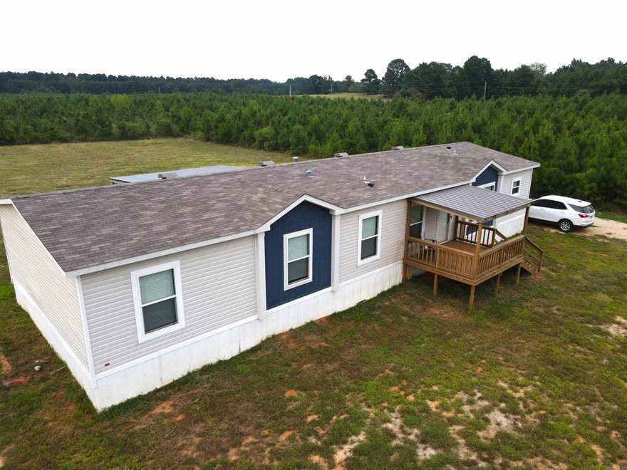 **Charming 2023 Farmhouse Breeze Manufactured Home** Discover modern living with a rustic touch in this stunning 2023 Farmhouse Breeze manufactured home. Featuring 4 spacious bedrooms and 2 well-appointed bathrooms, this home is designed with an open-concept layout that effortlessly blends the kitchen, dining, and living areas, making it perfect for family gatherings and entertaining. The kitchen is a chef’s delight, boasting a large island, ample counter space, and storage options. A versatile flex room offers endless possibilities, whether you need a home office, a playroom, or an additional lounge space. The property is surrounded by a picturesque 6-8 year old pine plantation, providing both privacy and a serene backdrop for your home. Mature pines on the southwest side of the property add to the natural beauty and offer shade and a sense of tranquility. This is more than just a home—it's your personal retreat, offering the perfect blend of comfort and nature. *Washer, dryer, 2 refrigerators, 0-inch Smart TV & mount, electric fireplace and 2 workbenches convey. **John Deere 3032E Compact Utility Tractor, attachments along with - can be purchased from Seller as separate property.