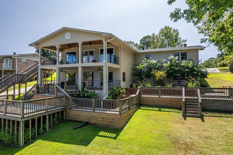 Comfortable Lake Hamilton ranch style home with great lake frontage with a stationary double boat dock (lift included) and jet ski ramps.  Main living area is a spacious open concept with hardwood floors, vaulted ceilings and gas log fireplace that flows onto the upstairs deck overlooking the lake.  Each of the four bedrooms includes its’ own private bathroom and makes each bedroom a private suite.  Outdoor living is lake living and this house features multiple levels of patios and decks for outside entertaining just off the main channel in a large cove.