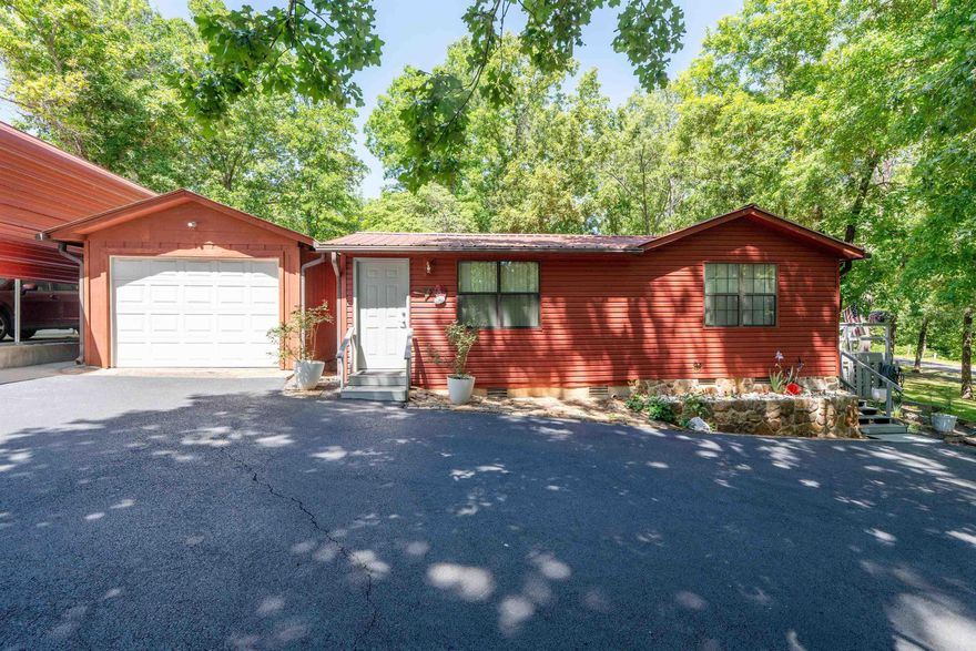 Welcome to 129 Jordan Lane at Water Rd in Choctaw Landing on beautiful Greers Ferry Lake in Clinton — just in time for lake season! This park-like, Lake Life & Fishing Life-ready property is tucked among towering trees and natural Ozark beauty, offering the perfect blend of relaxation, recreation, and functionality. Ideal as a full-time home, weekend getaway, or family entertaining retreat. Enjoy mornings on the screened porch with coffee and peaceful forest views, plus easy walk-to-swim-beach access via a designated trail. Evenings shine under the lighted lakeside gazebo with sparkling lake views. Home features approx. 1,605 SF, 3 bedrooms, 2 baths (including updated bath), and a 200 SF screened porch. A separate-entry flex space adds options for guests, hobbies, or extra sleeping.  Outside amenities include: • Oversized RV cover (Prevost-ready) • 288 SF detached garage with fish-cleaning station • 720 SF workshop/garage with heated & cooled space (man cave or she space) • Additional covered equipment storage • Raised garden beds & rock landscaping fire pit • Lighted lake views gazebo Lake, fishing, and park-life ready—this one is set up and ready to enjoy. Call today!