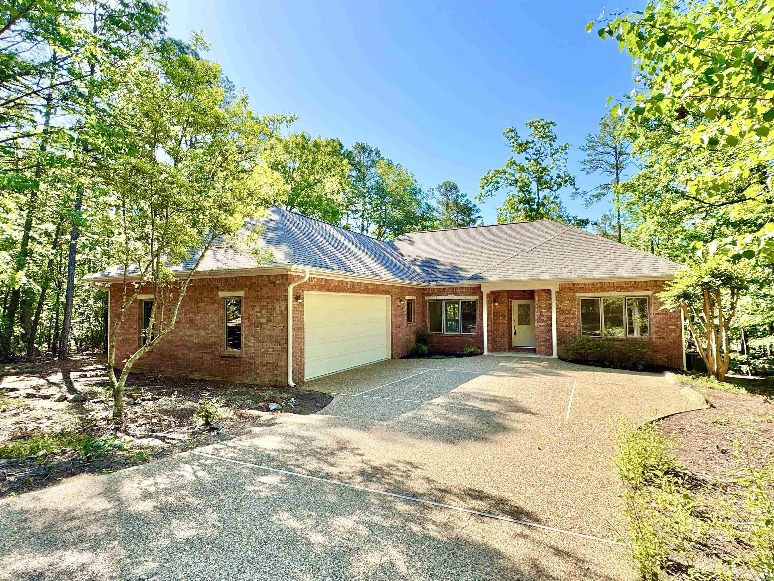 Well-maintained 3 bed, 2 bath one-level brick home near Glazy Peau Gate for convenient access in and out of Hot Springs Village. Located just minutes from multiple lakes, golf courses, hiking trails, and the Coronado Fitness Center. Features include a vaulted living room with corner brick fireplace, split bedroom layout, and a large screened porch overlooking a wooded backyard. The spacious kitchen offers abundant cabinetry, a center island, and a built-in desk. Fresh interior paint, new lighting throughout, new carpet in two bedrooms, and hardwood floors in main living areas. Primary suite includes access to the screened porch, a walk-in closet, and dual vanity bath. Oversized two-car garage and level driveway for easy entry. Enjoy quiet surroundings with the convenience of nearby amenities. First time HSV buyers have a $2000 one time buy-in fee. Call today for your private tour!