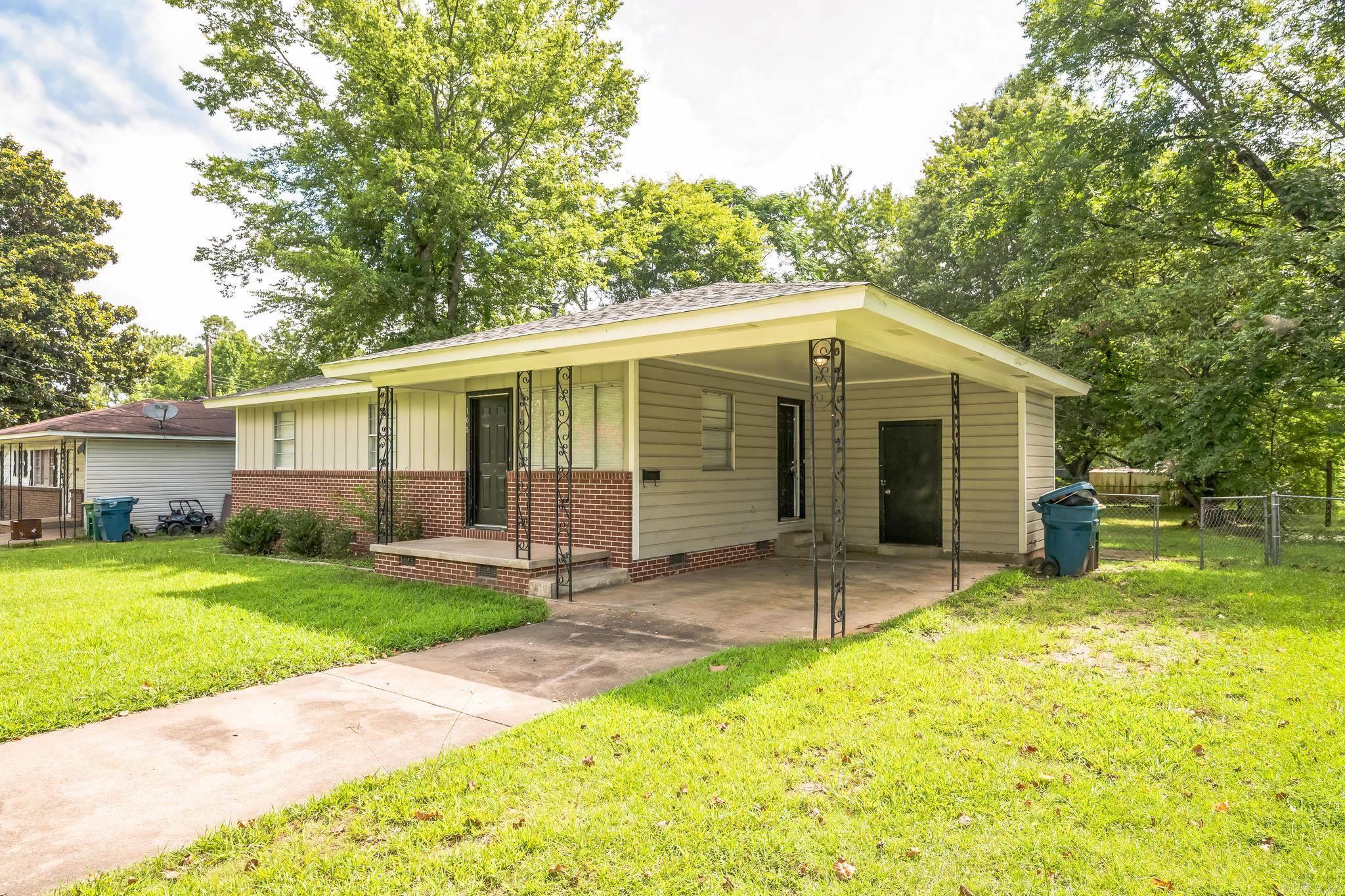 Set on a spacious, tree-lined lot, this charming single-story home blends comfort and convenience with a welcoming layout. Inside, the living spaces feature rich wood-style flooring, neutral paint tones, and ample natural light. The kitchen is equipped with crisp white cabinetry, stone-look countertops, and black appliances, including a gas range. Sliding glass doors off the dining area lead to a private backyard, perfect for relaxing or entertaining. The home offers multiple bedrooms with ceiling fans and generous closet space, along with updated bathrooms that include modern vanities and a combination tub/shower. Additional highlights include a covered front porch, vinyl siding, and a dedicated laundry area.