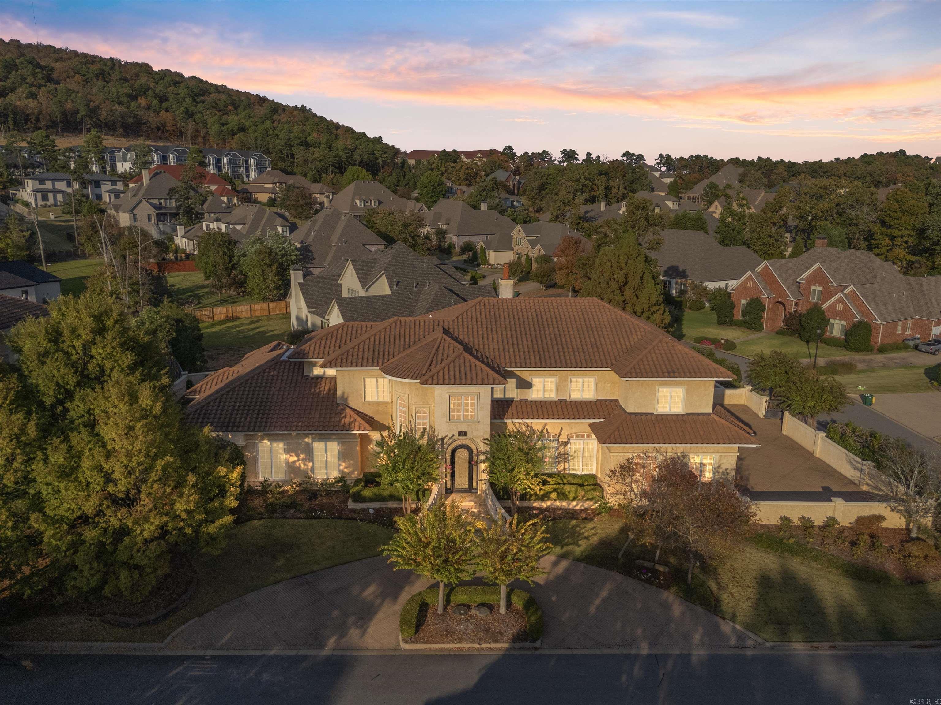 Nestled securely behind the private gates of Chenal Valley's Deauville Place, this exquisite estate offers the perfect blend of elegance and magnificent architecture in a premier golf course community. Fantastic floor plan, beautifully proportioned rooms with custom details and architectural excellence.The main level opens to a two-story foyer which flows into the two-story great room with fireplace overlooking the courtyard. Beautiful banquet dining room with gorgeous design planned for hosting family holidays and dinner parties. Kitchen is a chef's dream equipped with top-tier appliances, two islands and stunning Wood-Mode cabinets - this kitchen is as functional as it is beautiful. Den looks over the courtyard with large wet bar. Primary bedroom suite is the epitome of a retreat. Spacious room, cozy sitting area, luxurious bathroom with a walk-in steam shower, coffee bar and 2 expansive closets with built-in cabinets. The second level offers a game room and entertainment space with half bath along with 3 well-appointed bedrooms with en-suite baths. Backyard patio offers covered and uncovered spaces with an outdoor kitchen. Four car garage. Whole home generator plus so much more!