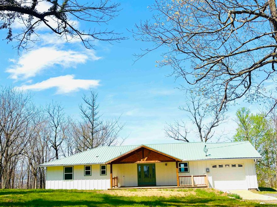 From the moment you pass the South Mountain Scenic Overlook up to this property, the stunning views of the Boston Mountains, the highest and most rugged part of the Ozarks, are like no other! Enjoy spectacular and breathtaking sunsets from the privacy of the new back deck featuring views stretching to the horizon painting a panoramic postcard of sheer bluffs, Oak, Pine, Hickory forests, rivers and creeks that changes with every season! This beautiful 3-bedroom home offers almost 1500 sq ft and has been completely renovated to brand new! Fresh new paint, beautiful hardwood flooring, completely updated bathrooms including a large walk-in tile shower with glass doors, Maple vanity with dual sinks, and all new kitchen with new stainless appliances, Maple cabinets, and quartz countertops. The bedrooms have spacious closets with built-in shelving, the primary having dual closets, a build-in hall cabinet with drawers, maple cabinetry in the laundry and main bath, a large hall closet that could also be used as a pantry, plus additional cabinets and shelving in the garage. New insulated windows and doors, new covered front porch and front door, exterior paint, guttering, and new sidewalks.