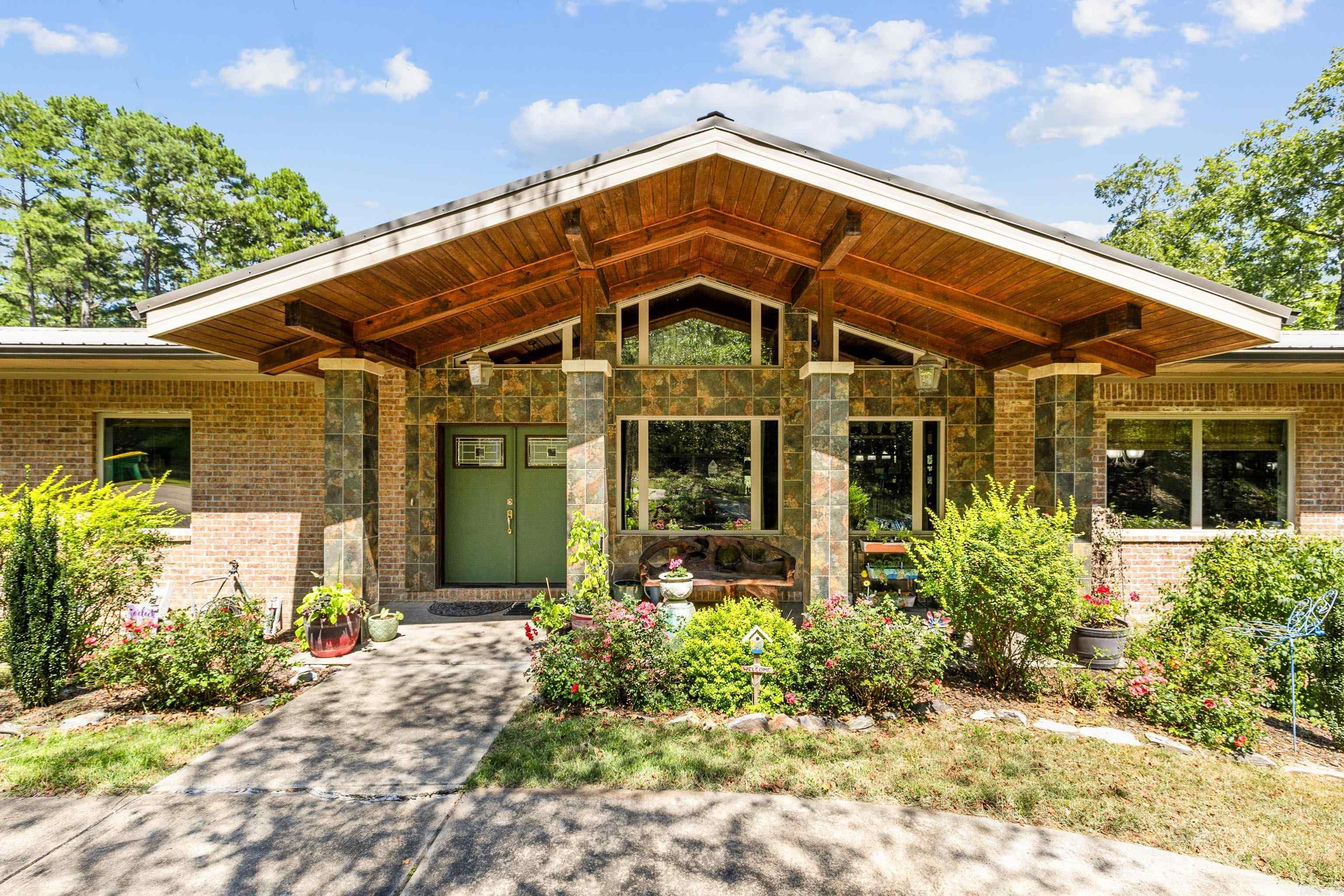 Nestled within a private gated community, is a charming mid-century style home, set against the backdrop of natureās beauty. From the screened-in balcony, enjoy the sight & sound the great outdoors featuring a creek flowing through the property, creating a perfect retreat. Energy-efficient features include a metal roof, low-E windows with custom shades, and foam insulation ensuring comfortable temps year-round plus low utility costs. Two 50-gallon marathon water heaters a whole-home generator, designed for peace of mind. Indoor & outdoor living spaces are enhanced by cozy fireplaces, w/an additional firepit for gatherings. There is a 2.5-car garage with additional site-built storage building. Vaulted ceiling extends from the front porch through the living room and continues to the back porch, creating a sense of grandeur. Main level has two bedrooms, two bathrooms, & office. The kitchen, with its modern maple cabinets, adds a sleek touch to the home. Two pantries and an abundance of custom-built cabinets for ample storage. Lower level offers an additional office, a cozy den, bedroom, bathroom & a large storage room/ workshop spaceāperfect for hobbies or projects. Must experience!
