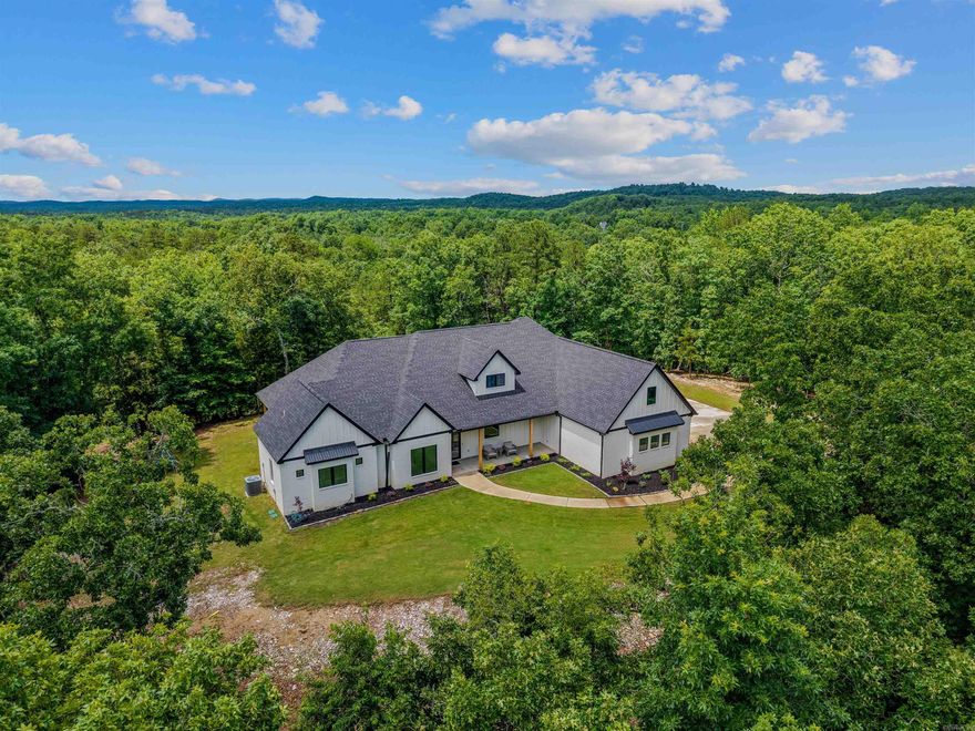 Welcome to this stunning custom-built home nestled on 5.93 acres of peaceful, tree-lined property. Upon entering through the iron double doors, you'll be greeted by soaring ceilings and numerous windows that fill the home with natural light. The spacious living room features convenient built-ins surrounding a cozy fireplace. The chef's kitchen impresses with a large waterfall island, beautifully crafted maple cabinets, a hidden drawer dishwasher, and a walk-in pantry. It opens seamlessly into a large dining area, perfect for entertaining. After a long day, retreat to the primary suite, where you will find a sitting area, private access to the outdoors, his and her closets, and large walk in shower with rain shower head. Boasting 5 bedrooms, each with its own bathroom, the layout offers every convenience. Heading outdoors, you will find an enclosed patio with a second fireplace, an ideal spot for enjoying your cup of coffee. Rounding out the exterior features is a 3-car garage, extra concrete for parking, and a sprinkler system. With breathtaking vista views, this residence offers the perfect blend of elegance and tranquility just minutes between Benton and Little Rock.
