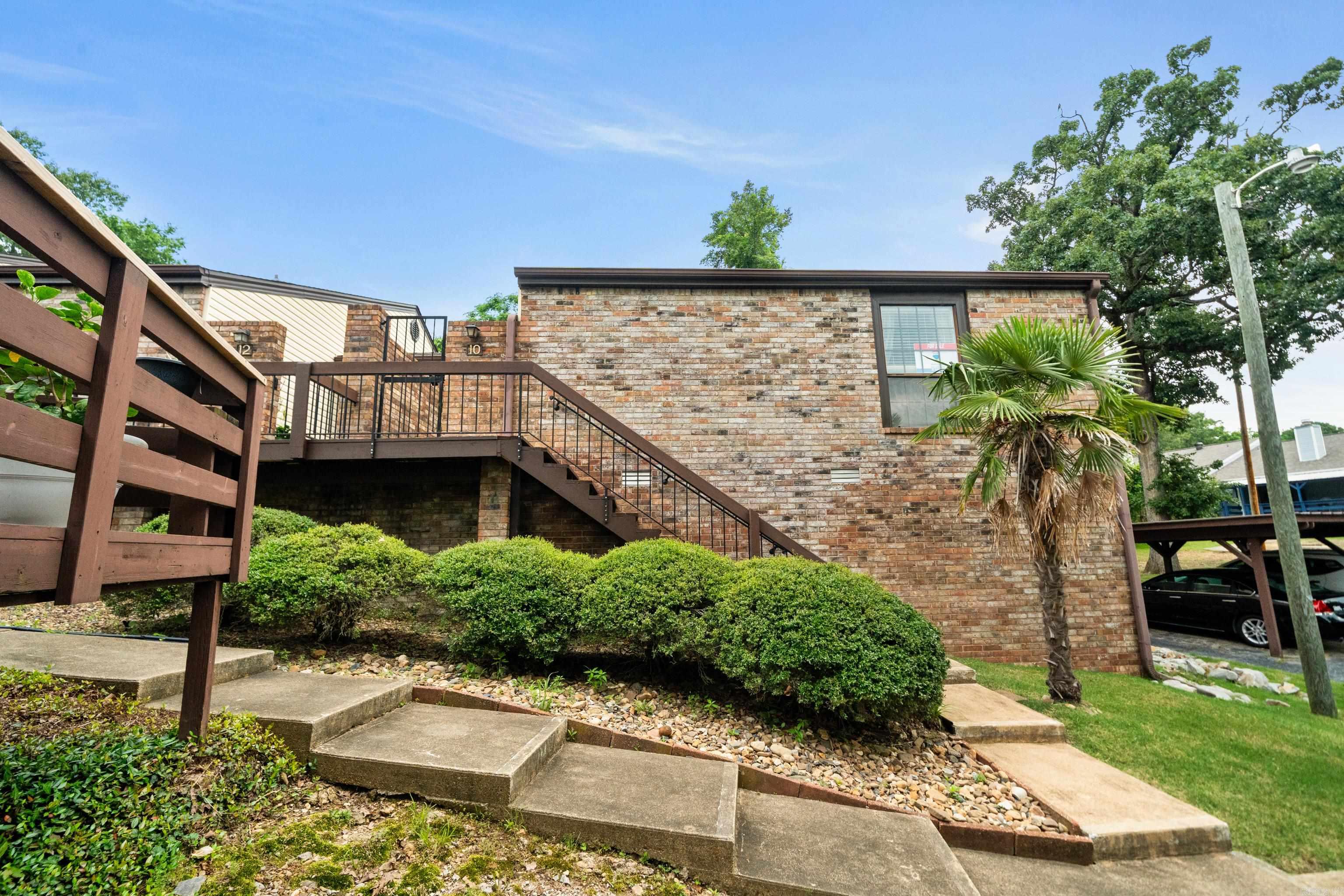 Discover your perfect retreat in the heart of Hot Springs! This beautifully updated two-bedroom, two-bath end-unit townhome offers modern comfort in a peaceful, green neighborhood. Enjoy single-level living with a bright, vaulted great room and new laminate plank flooring throughout. The kitchen features brand-new appliances. A spacious master suite offers a quiet escape with its own patio walkout. Step out onto the large deck overlooking lush green space—ideal for morning coffee or evening barbecues. Covered parking is just steps away, and you're minutes from hospitals, shopping, golf, dining, downtown, and three stunning lakes.