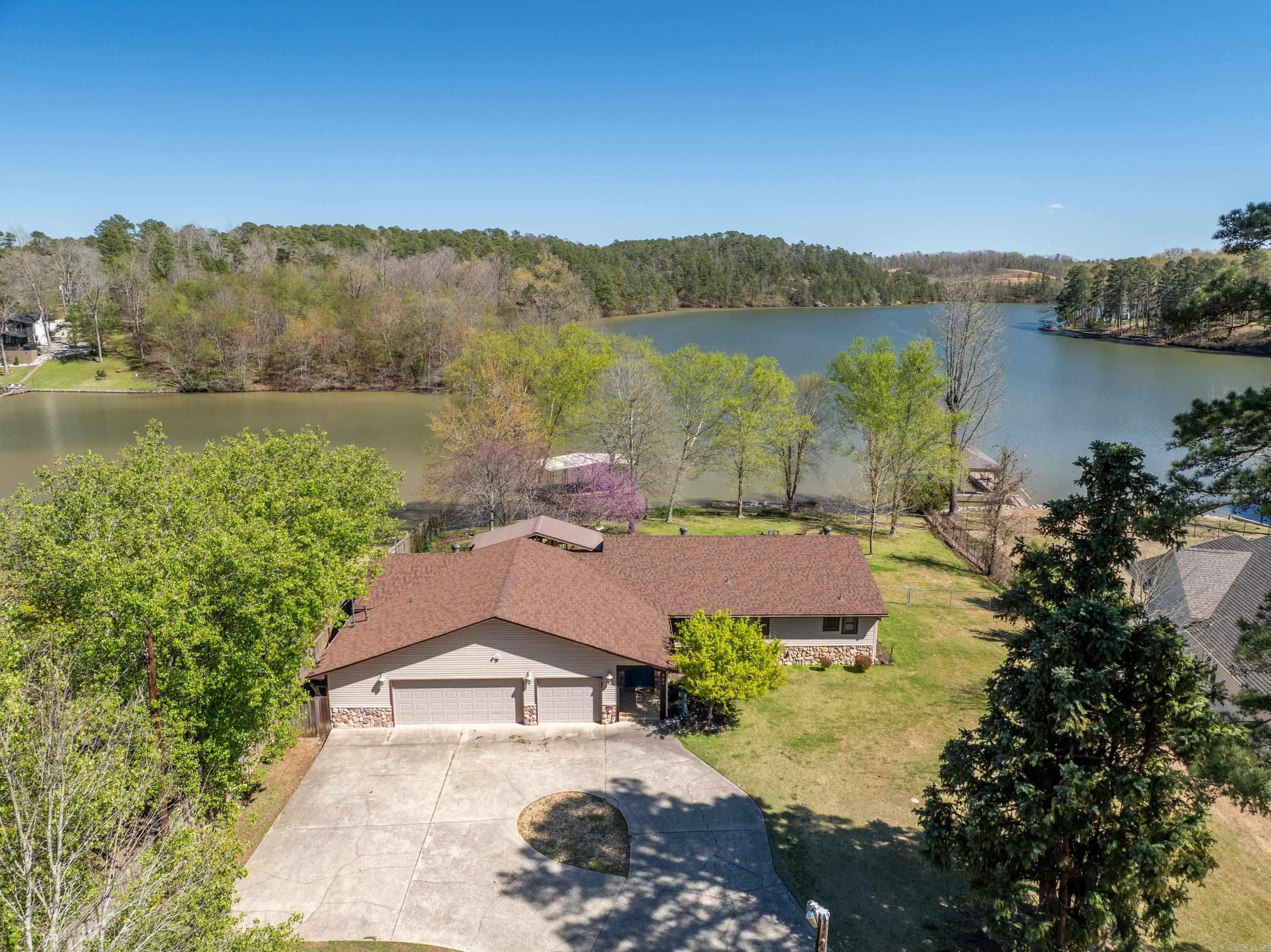 Wow! A single-story, 4 bedroom home sitting on a large level-lot on Lake Hamilton with a covered boat slip, swimming deck, fenced in backyard and large covered patio?? Rare is an understatement. So many selling features including a three-Car Garage, Two Laundry Rooms, gorgeous views of Lake Hamilton from every bedroom, and 150 feet of lake frontage!