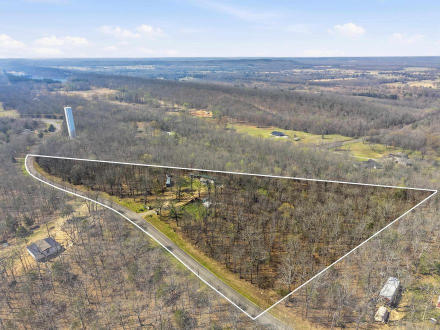 Discover nearly 8 acres of peaceful, usable land in Vilonia offering privacy, natural beauty, and a self-sustaining lifestyle. The property features established fruit and berry trees, a muscadine vineyard, blackberry patch, and garden space, along with over a mile of scenic walking trails, natural moss pathways, and multiple fire pit areas. A seasonal spring adds charm, while a fully screened “bungalow” tucked in the woods provides a unique space for camping or a rustic guest retreat. A 40-ft shipping container that is used as a workshop with built-in shelving and workbenches conveys, along with a 40-ft 5th wheel camper for additional living or guest space. Property also includes a septic system already in place. This one-of-a-kind property is perfect for those seeking space, privacy, and a connection to nature just minutes from town.