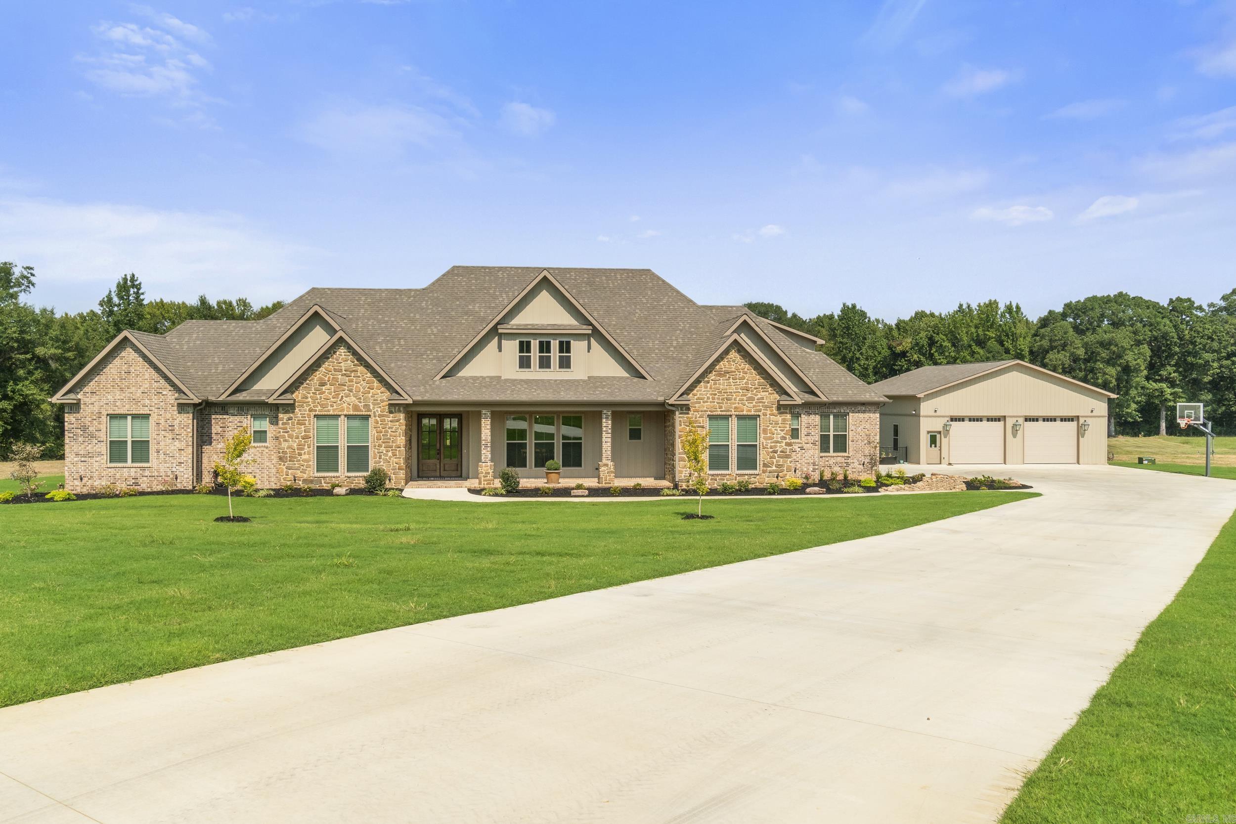 Discover the perfect blend of luxury, space, and privacy in this stunning 5-bedroom, 4-bath traditional-style home on 4.4 acres in a beautiful gated community just minutes from downtown Searcy. Ideal for those who value peace, privacy, and convenience, this estate features a serene pond, a 3-car attached garage, and an incredible secondary garage/workshop with two oversized overhead doors—large enough for RVs—with a full kitchen, laundry, and bath, easily convertible into a separate apartment or guest house. Inside, enjoy two fireplaces (one in the sunroom, one in the main living room), spacious bedrooms—including the master on the main floor—and thoughtful details throughout. With horses and cattle allowed, high-speed internet, and proximity to the airport (perfect for private flyers), this is a rare opportunity to live rurally without sacrificing access. Only 7 minutes to downtown Searcy and 40 minutes to Little Rock. Homeschool-friendly and ideal for remote work or travel-based lifestyles.