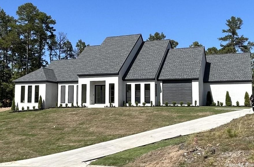 Quality abounds w/custom finishes. Backdrop of woods for privacy. Concrete brick, 12' & 10' ceilings, 8' windows and doors, barrel foyer, open living. Chefs kitchen- quartz, antique mirror back sp., 6 gas burner/griddle. Wet bar frig/ice, serving bar, island. Mud room, large pantry, 21'x17' master suite w office/exercise room, zero threshold showers, enormous closet. Bonus up w/2 BR & 2nd laundry. Patio 1/2 bath- elec. heaters, tongue & groove ceiling. 1000 SF garage. August Completion. See agent remarks.
