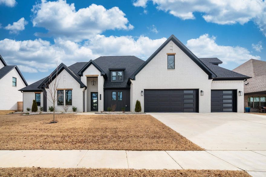 This 2022 modern farmhouse build directly across from the lake features 5 BR/ 3.5 BA with a media room/bonus area upstairs. This home boasts vaulted ceilings, 12 foot ceilings in the additional 3 bedrooms on the main level, with captivating accent walls throughout, beautiful tapered chimney/fireplace, modern fixtures, hidden walk in pantry with additional refrigerator hook up, upgraded Navien tankless water heater, and Graber blackout roller shades. The primary bedroom is a very spacious with a stunning ensuite bathroom including a free standing bathtub with tile surrounding and separate tiled shower with dual heads, the custom built master closet connects to the laundry room. The covered back patio has an additional gas log fireplace with plenty of space to enjoy the fully fenced in backyard. The mudroom is directly located off the garage entry with a half bath. The 3 car garage with epoxy floor has a universal Tesla Charger and additional 240 V plug for another EV car/truck. The front and backyard has irrigation and the flowerbeds have been refreshed with rock.