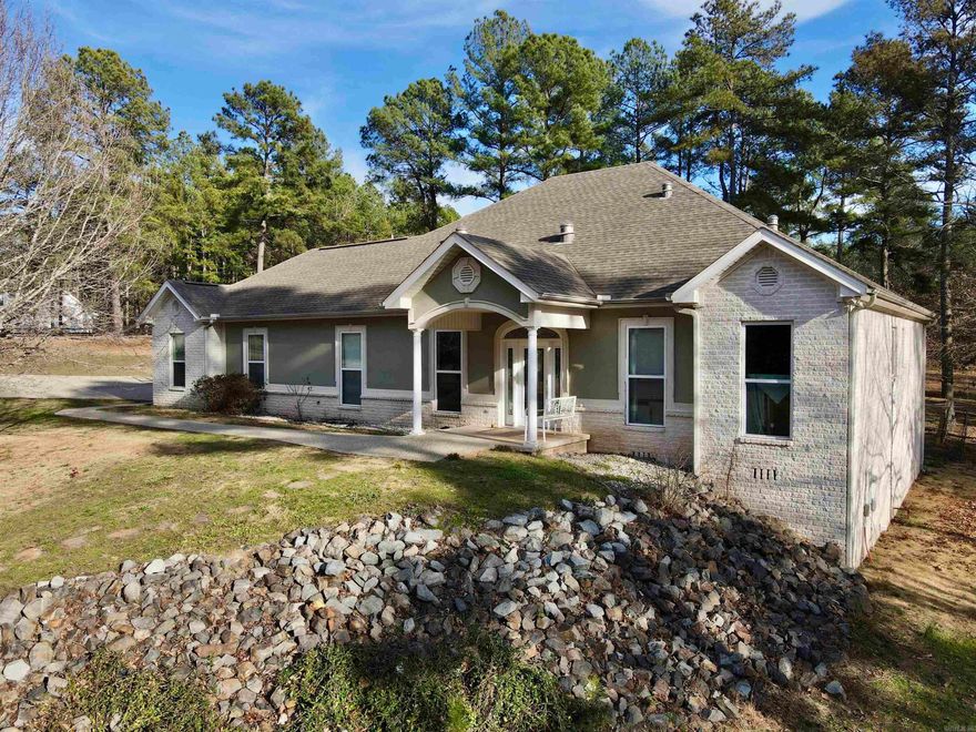 Located on nearly 3 acres in the desirable Brookhill area, 780 Brookhill Ranch Road offers privacy just minutes from the Hot Springs Village gates. This 2008 custom-built home features an open floor plan with vaulted ceilings and significant natural light from large windows and sun tubes. The interior is updated with new Green Guard Gold certified waterproof LVP flooring throughout. The kitchen includes custom cabinetry, ample workspace, and a large pantry, while the primary suite is designed with a functional office nook and a walk-in shower. Additional living space includes a heated and cooled sunroom for year-round use.  A standout feature of the property is the 60x40 detached shop. This versatile building includes a loft and a dedicated heated and cooled area equipped with its own bathroom, making it ideal for a workshop or hobby space. This property efficiently combines a well-maintained residence with substantial utility and acreage.