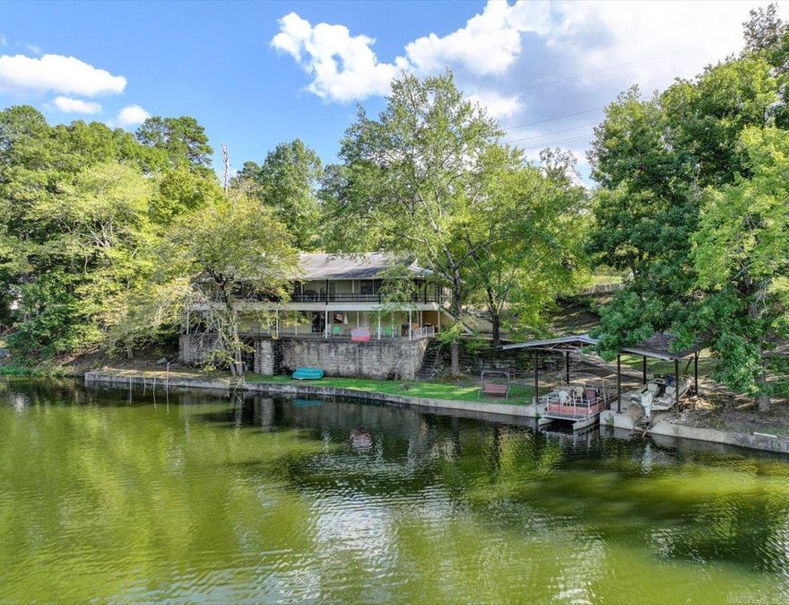 Amazing Location - Waterfront Retreat on Lake Catherine. This home was built by a craftsman and used for many years as a family lake house cabin. A solid slab supports the 2 stories and basement. The wood interior creates a warm, fun atmosphere where everyone knows they can relax and enjoy lake living. The main floor enjoys an open floor plan with living, dining, and kitchen, as well as 2 large bedrooms, baths, and a laundry room.  The basement area is an open floor plan with a game/family room, bedroom, kitchen, and bath. Both levels enjoy a wide deck running the length of the home with amazing views of Lake Catherine. The main level deck is screened for year-round enjoyment.  Lakeside, there are concrete, covered boat stalls for multiple boats and a concrete bulkhead to protect the shoreline. Only 6 minutes to Remmel Dam and right across the Ouachita River there are many trails at Lake Catherine State Park.  Live full time by the lake or make it your own lake family retreat for endless vacations. This is the perfect location for you.   Agents - Call Showing service to schedule all showings.