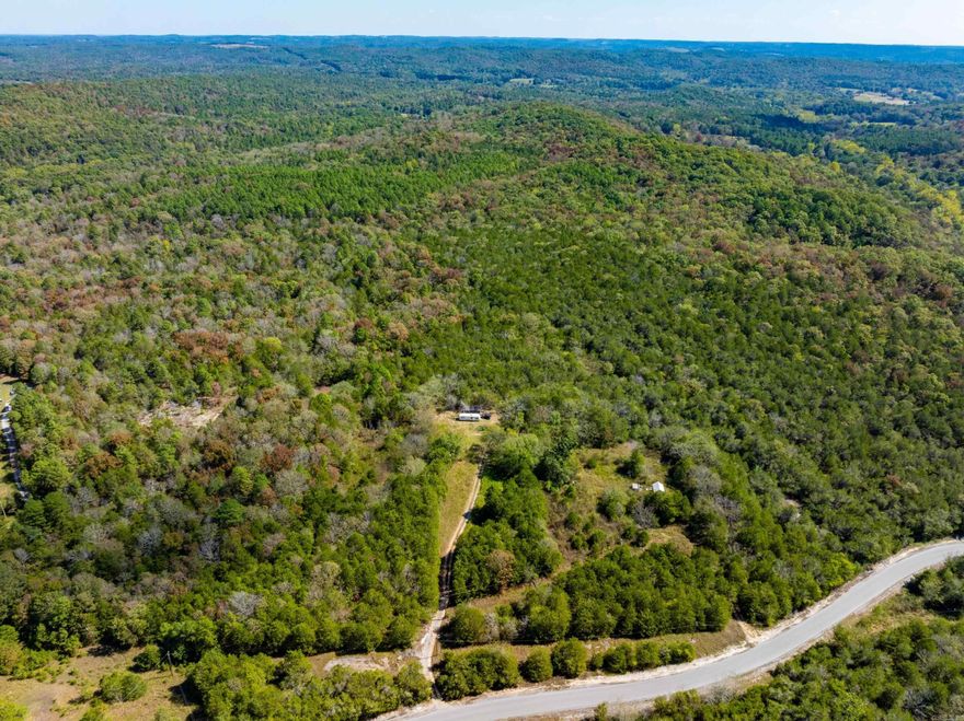 Secluded 9.5 +/- wooded acres with a creek and cabin between Cave City, Batesville & Cushman—just off the paved Sandtown Rd on Pine Hill Rd. Mostly timber with a quiet clearing, garden spot, and abundant wildlife. The simple cabin has electric service; no running water inside at present. A well is on site and the pump (included) has not been installed—great project/handyman opportunity to finish it your way. Excellent small hunting tract or weekend base with room to add trails/food plots. Camper does not convey. Easy access, private setting, and the hard-to-find mix of creek, timber, and improvements at an affordable size.