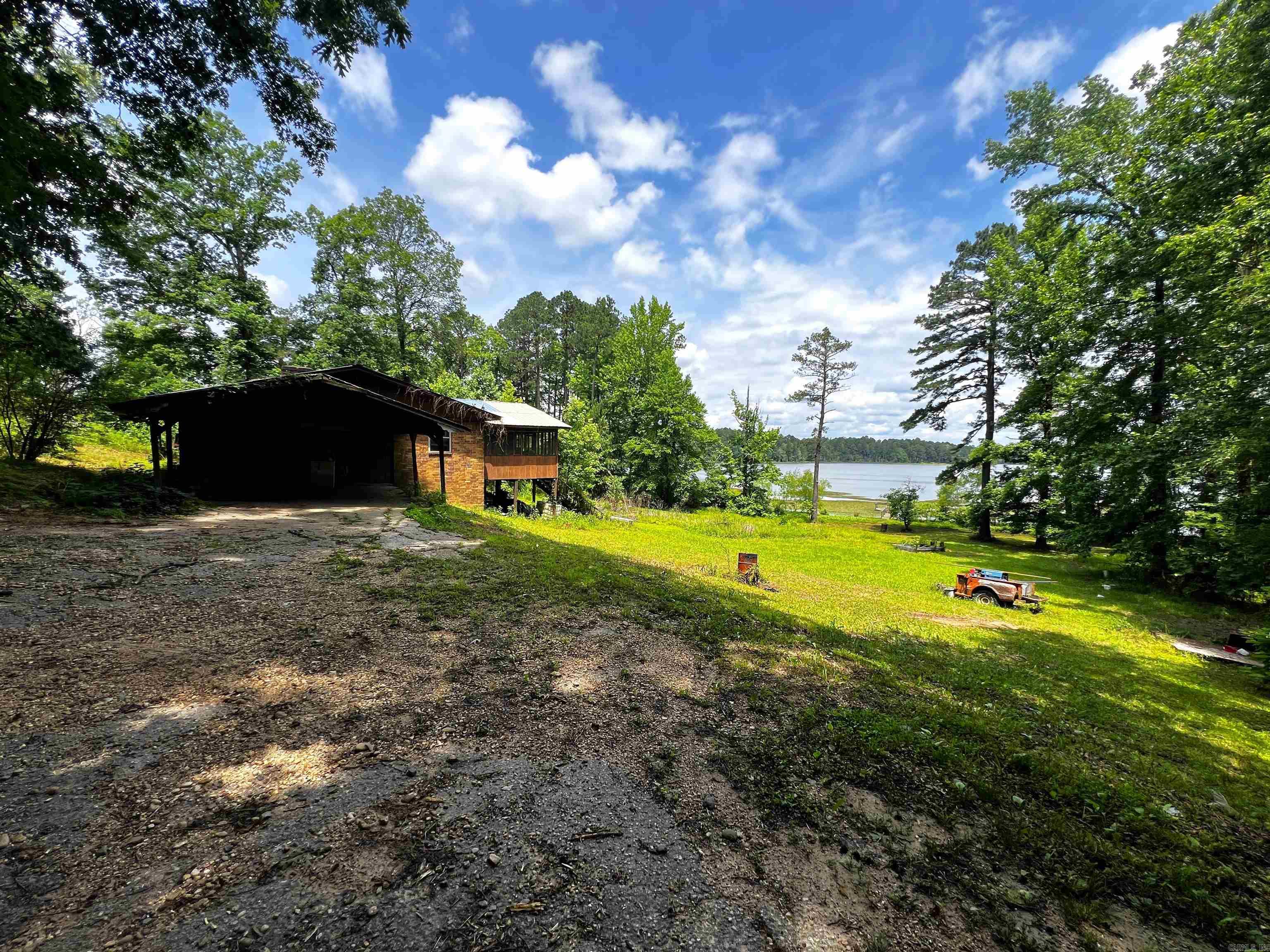 Waterfront property on Cox Creek Lake with a dock on the water! Open floorplan, kitchen with custom built cabinets & refrigerator stays, 4 bedrooms, 2 bathrooms, laundry room, extra large bonus room, carport, screened porch. Wood burning fireplace. House has city water but there is a well that can be used for watering the lawn. Lots 5 & 6 make the .67 acres.