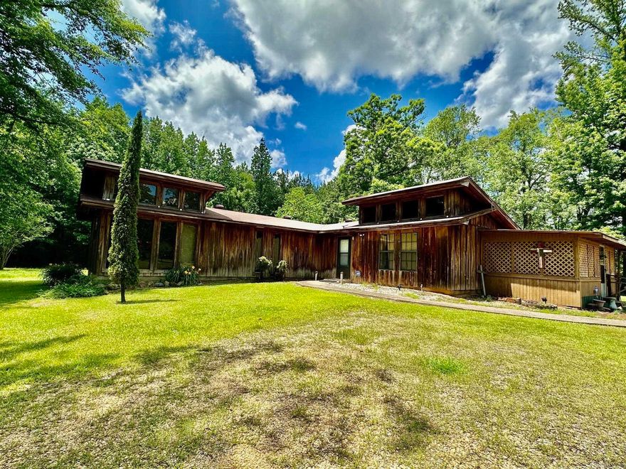 Great starter home that is outside the city limits on 2 acres.  The interior has been recently painted.  Kitchen has a large bar, tiles floors, good cabinet space, refrigerator will convey.  The living room has a nice fireplace with great windows for natural light and you have bonus space in the sunroom with a nice view of the back of the property.  Primary bedroom has 4 closets. (This room use to be two bedrooms and was converted to one large bedroom) Hall bath is shower/tub combo. The guest bedroom has large windows for more natural light.  This bedroom has a shower and toilet attached. This home also has a screen in back porch!  The property has a large workshop.  The shop has water and a window unit along with a gas heater.  The metal storage building will convey but the metal carport will not.  The home is on Hamburg water, but the well system is available.  Roof is approximately 2 years sold.  Pretty piece of land just waiting for a garden to be planted and make this home yours!