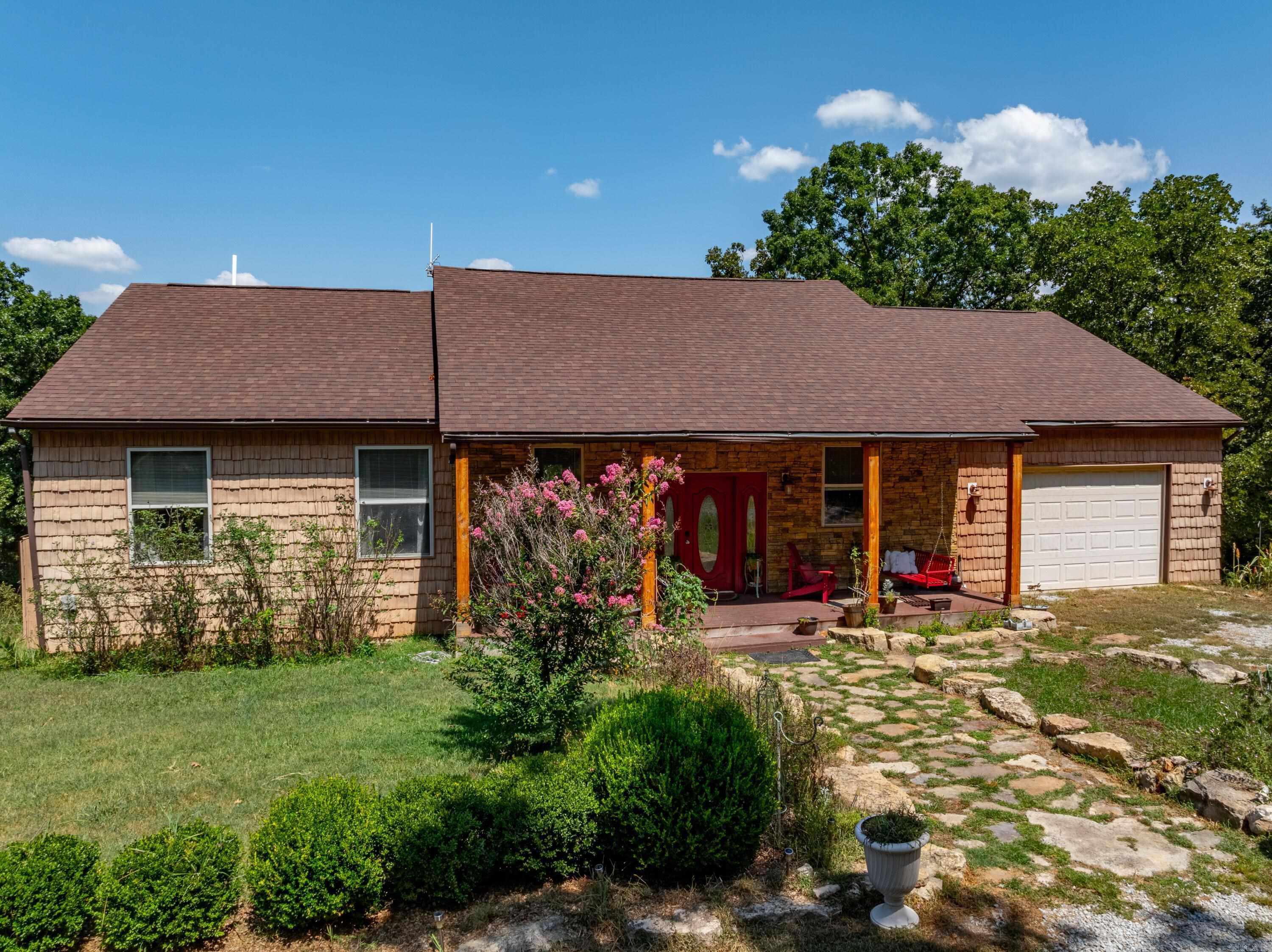Rare and expansive 23 +/- acres along the serene shores of Bull Shoals Lake, this exceptional property offers a unique blend of meticulous craftsmanship, natural beauty, and practical amenities. Originally begun in 2008 by the parents of the current owners, the home was thoughtfully completed by their children, who ensured that every detail was carefully designed and meticulously finished in this last year.The home itself boasts custom cherry kitchen cabinets, Brazilian cherry floors, travertine stone in the kitchen, all-wood trim, cedar-lined closets, and tiled walk-in showers. The ceilings in the living room soar to 16 feet, while the rest of the main level features 10-foot ceilings, and the fully finished basement has 8-foot ceilings. An office with custom-built shelving offers a perfect workspace, while the master bedroom features a Tiffany ceiling fan and private access to the expansive back deck.The main level of the home offers 1,800 +/- square feet of living space with the finished basement adding an additional 1,800 +/- square feet of living space with an attached garage.The property includes a large shop.Fully covered boat dock with two boat slips and a swim platform.