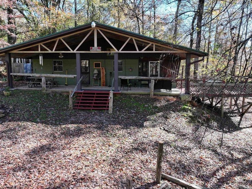 This charming cabin offers a beautiful view of Lake Greeson and is located in the Bennett Cove area on a dead-end road. Just a short distance from the water, you’ll find easy access to lake activities and recreation. The screened-in porch provides a great place to relax, while the deck and outdoor living space add to the appeal. Inside, the open layout features exposed beams, a stone fireplace, and large windows that showcase the setting. With 2 bedrooms and a sunroom that can serve as extra sleeping or flex space, this property is ready to enjoy as a weekend retreat, full-time home, or short-term rental opportunity.