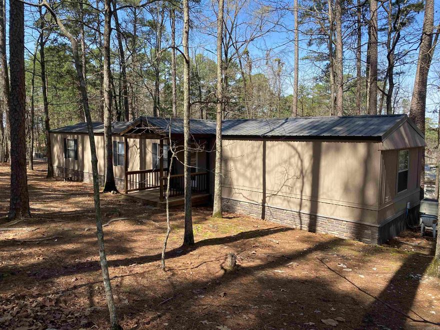 Located in Harbor South at Mountain Harbor Resort on beautiful Lake Ouachita. This 3 bedroom, 2 bath, approximately 1,216 sq. ft. mobile home is ready for its new family. The open living/dining area separates the primary bedroom and bath from the guest rooms. Kitchen has recently been updated with granite countertops, new paint, tile backsplash AND new flooring throughout the home. You will love the large, covered & screened deck with its vaulted ceiling & vinyl curtains.  The open deck is a great size for gilling or just hanging out after a day on the lake.  Circle drive for easy in and out and parking for family & friends.  Mobile home sits on .43 m/l acres and in Harbor South you will own the land it sits on!  Call today for your private showing.