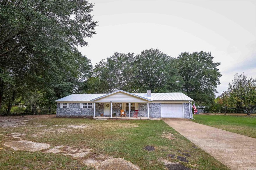 Welcome to your picturesque retreat! This charming 4-bedroom, 2-bath brick home sits on a sprawling 9-acre parcel, offering the perfect blend of country living and modern comfort.   Step inside to discover updated flooring and windows and a wood-burning fireplace that exudes warmth and invites cozy evenings. The metal roof not only enhances durability but also adds a touch of character to this inviting abode.  Quartz countertops and a walk-in pantry might be your favorite aspects of the airy kitchen.  Outside, your possibilities are endless. With a private pond for serene moments, a barn for your hobbies or animals, and various outbuildings to accommodate your needs, this property offers the space you've been dreaming of. Gather around the fire pit for starry nights and memorable conversations.  This home is conveniently located outside of the hustle and bustle of town, ensuring tranquility and space to breathe. With numerous upgrades throughout, it's the perfect blend of classic charm and modern convenience. Don't miss the opportunity to make this welcoming retreat your own. Schedule your personal viewing today!