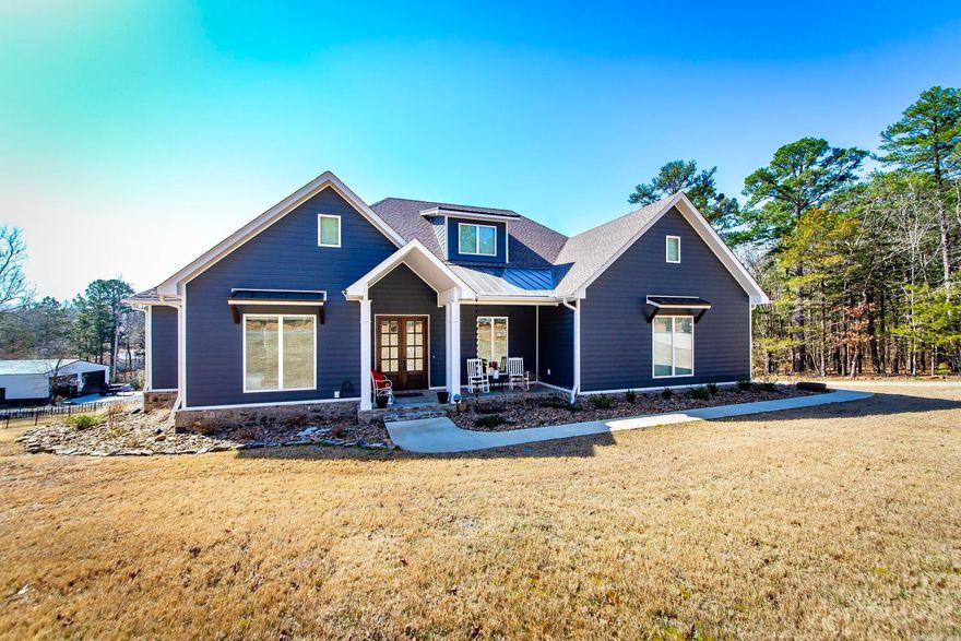 Welcome to this exquisite new construction home. Located just outside of Fairfield Bay & less than 1 mile from Fairfield Bay Marina so no HOA. Offering a perfect blend of luxury & comfort. Expertly crafted by a local builder for his personal residence, attention to detail is evident throughout. Enjoy a convenient walk easement to the tranquil shores of Greers Ferry Lake. Spacious Living Areas: With 2,316 sq ft on the main floor & an addl 400 sq ft bonus room upstairs, there’s plenty of room for family & guests. Experience the convenience of a large pantry featuring a coffee bar. The heat & air is a dual fuel system. The house is wired for a generator.  Soaring 10' ceilings, upgraded luxury vinyl flooring, & leathered granite countertops create a sophisticated atmosphere. Entertain with family & friends on the covered deck. This home is very energy efficient with spray foam insulation & the Everlast siding & composite decking make this home low maintenance. The programmable sprinkler system will keep your landscaping lush. Keep your family safe with a built-in storm shelter & ample storage in the insulated basement & the spacious 30X45 shop building is great for your lake toys.