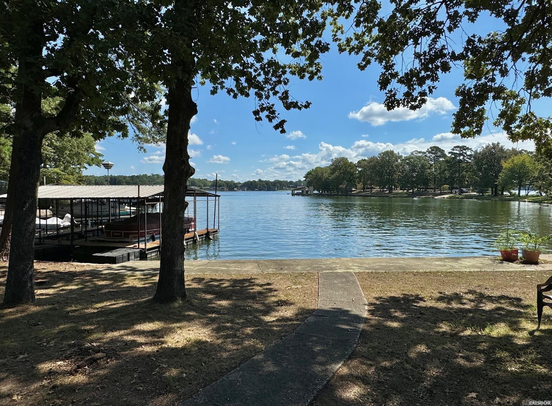 3 bedroom, 2.5 bath lake home on just shy of an acre of land with approx. 115' of frontage on Lake Hamilton. The views from the property are truly stunning, and the wooded surroundings provide a park-like setting. The home itself needs some cosmetic updating; however, it has a nice open layout and would transform easily. The home has a partially finished basement that, if completed, would add considerably more square footage. It's already framed for two more bedrooms and a bathroom. The roof is brand new. Also included is a large covered dock with two boat slips. Very convenient location to the bypass.