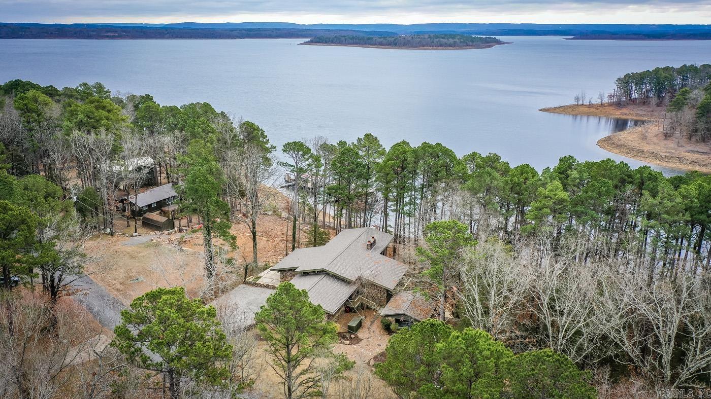 Fully Furnished Lake House with everything there to stay, plus includes one Boat Slip in a two stall community Dock w/Boat Lift (Neighbor to the right owns the second slip & Dock is the green roof dock with path in backyard that veers to the right towards the dock). New architectural roof 2022, Solar power permitted & installed on dock 2022, 10,000lb boat lift installed 2022, Updated interior lighting 2022 including adding 16 LED cans in kitchen, Replaced all back patio handrails and decking 2023. Main House has approximately 2,354 sqft with 3 bedrooms & 2 full bathrooms. Guest House has approximately 432 sqft with one large bedroom (Or is can be used as a bunk room, game room, man cave etc. ) Fireplace in Guest house is antique & for looks only, not for use. Two nice size storage rooms off of the carport.