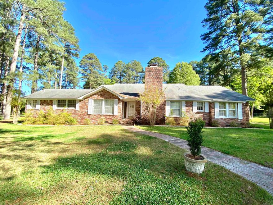 Beautiful 3-bedroom, 3 full bath home situated on 2.28 peaceful, shade-covered acres with an inground pool, guest house, and plenty of space for everyone. The guest house offers 2 bedrooms, 1 bath, living room, and kitchen—perfect for extended family, guests, or rental potential. The main home features a spacious family room with a brick fireplace and an additional living area that could serve as an office, complete with built-in bookshelves and abundant natural light. A dining room sits just off the kitchen, while the eat-in kitchen has been updated with new cabinetry and newer stainless steel appliances. The primary suite offers privacy and includes a walk-in closet. A large sunroom off the primary bedroom and kitchen provides a bright space to relax or entertain. Two additional bedrooms are located on the opposite side of the home with a shared full bath. The home also includes a spacious laundry room, covered storage, and an additional storage room off the sunroom. Outside, enjoy the partially fenced backyard with a new deck and sparkling inground pool—perfect for outdoor gatherings. Two carports and ample storage complete this property. Property is being sold "As Is".