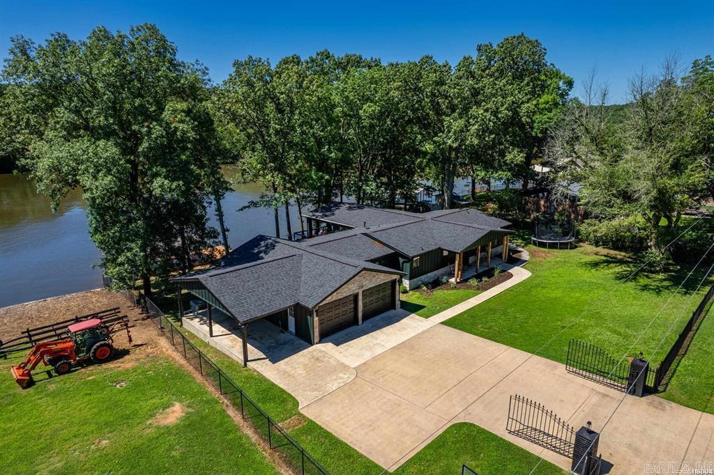 Stylish lake home that has it all....one level flat lot, 156' Lake Hamilton frontage, covered boat dock with deck, covered outdoor porch, beautiful floors, walk in pantry, separate office, laundry room, bonus room, open kitchen with island, master suite with walk-in closet and a gorgeous bath, two car garage plus additional covered parking, new roof, new windows, and so much more.