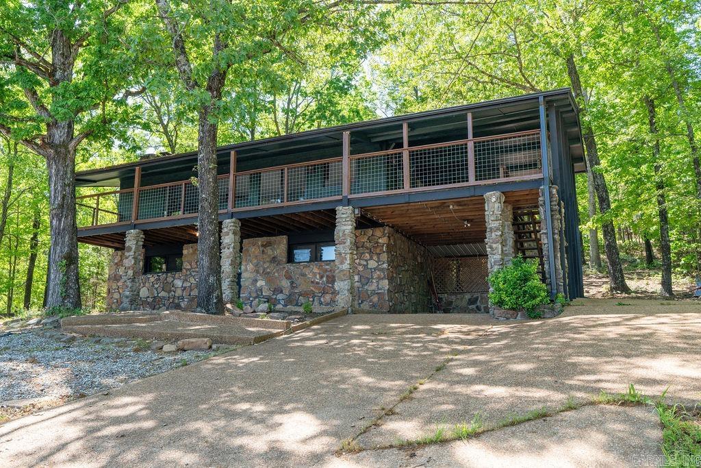 Fully renovated and beautifully designed, this 4-bedroom, 3-bath home offers stunning, distant views of Greers Ferry Lake in the spring/summer and even more expansive views in the winter, 2,610 sq ft of modern living space across two levels. 2 bedrooms and optional 3rd or den/sunroom/study upstairs, with one bedroom, sitting area and bath downstairs. Completed in September 2024, updates include all-new flooring, a stylish kitchen with new appliances, open concept, updated bathrooms with tasteful design features, interior/exterior paint, and beautiful tile-floored deck perfect for outdoor dining while taking in the view. The home features two fireplaces, a great room, and a game/den area. Enjoy a spacious 36' x 6' main deck, a fire pit lounge area, and landscaping upgrades. Inviting back decks with the cozy feel of the wooded area surrounding the home. The roof was replaced in 2018, gutters in 2023. A carport and additional parking pads offer plenty of space for guests. Ideal as a primary residence or short-term rental—permit will need to be obtained. Private septic means no sewer fees, and resort amenities add extra appeal. Take a look at this gorgeous home.