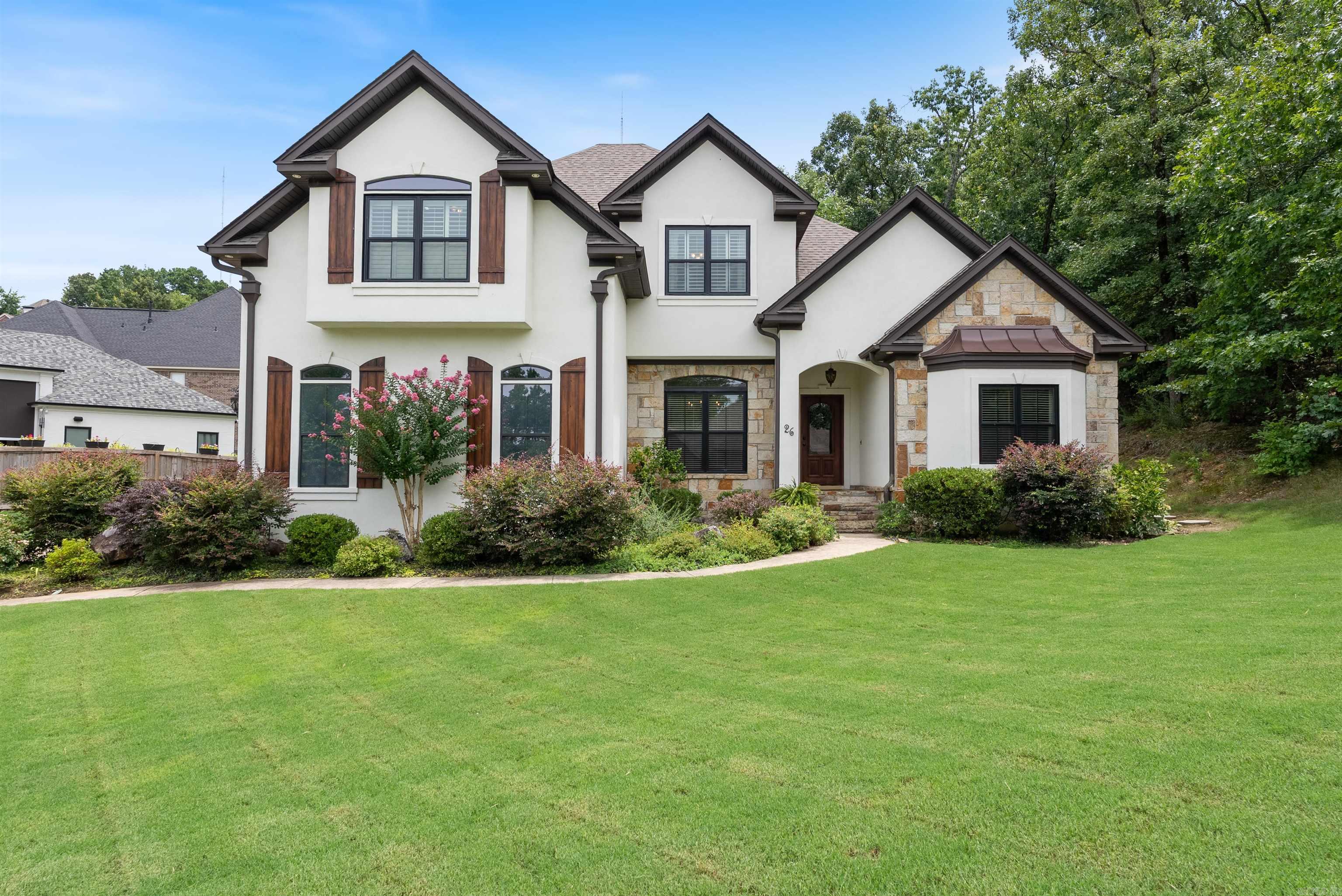 Tucked away in the desirable Challain Place neighborhood of Chenal Valley, this beautifully updated modern farmhouse sits at the end of a quiet cul-de-sac, surrounded by mature trees and is next to dedicated green space offering both privacy and connection to nature. The wooden front door opens to a 2-story foyer and the dining room with convenient access to the kitchen. The great room features a charming fireplace with windows overlooking the backyard. A well-appointed kitchen features granite countertops, breakfast bar, tiled backsplash, electric range and double oven, dishwasher and a desk with storage and shelving. Adjacent the breakfast area. The primary suite is privately situated on the main level and offers a retreat-like feel with hardwood floors and a walk-in closet. The en suite bathroom includes his and her sinks, a large soaking tub, walk-in shower, & a private water closet. Upstairs is a landing area along with 2 spacious bedrooms, a large bathroom (where each has their own private vanity with sink and toilet), and a versatile game room and/or 4th bedroom. Additional features include deck with synthetic decking, new roof installed in 2021, new hardwood floors & more!