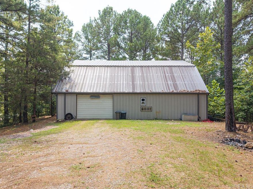 Are you in search of a secluded residence nestled among five acres of majestic pine trees, with convenient access to Lake Ouachita and various recreational activities, all within a 45 minute drive to Hot Springs? This home and shop may be the perfect solution for you. The shop encompasses approximately 2,500sqft, featuring living quarters on the second level, which includes 1,500 +/- sqft of open concept living space. This area, with fresh, grey paint, comprises an eat-in kitchen, 3 bedrooms, 2.5 bathrooms, and a utility room. The shop offers ample space for vehicles, SUVs, and boars, along with a heated and cooled office equipped with a half bath. It is wired with 220-volt power and adequately lit, making it ideal or automotive projects, recreational activities, or other pursuits. With 5 acres of land, the property also presents opportunities for investment projects, such as rental storage units or short/long term stays. A small, year-round creek runs along the southern edge of the property, enhancing its charm. Given its proximity to Lake Ouachita, alone with nearby fishing and hiking trails, the possibilities for this property are truly limitless.