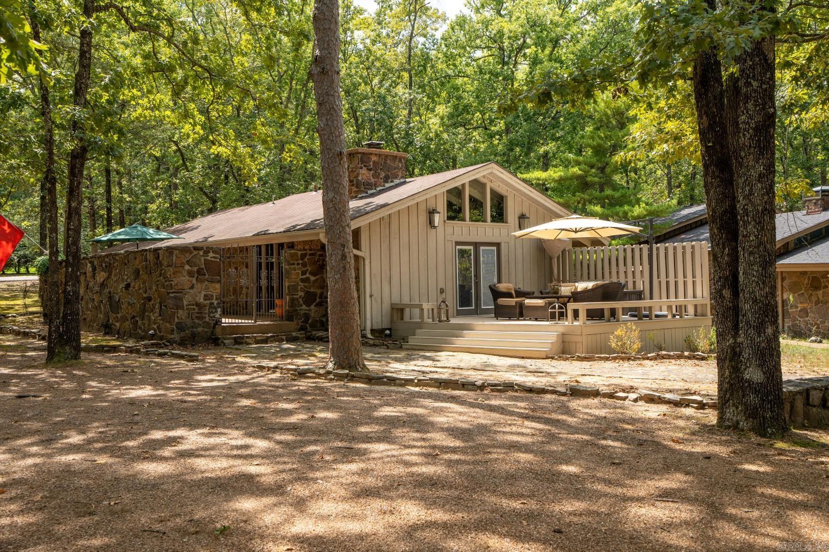Charming 3-bedroom 2-bath cottage on EDEN ISLE! Located around the corner from Eden Isle Marina, this super cool original Eden Isle home has vaulted ceilings throughout, stone and wood exterior, private courtyard plus a deck for people watching and deer watching! Wood-burning fireplace, new kitchen tops, sink and dishwasher. A lovely wooded setting perfect for a lakehouse on Eden Isle! Firepit and LOTS of parking! A rare find on the island!!!