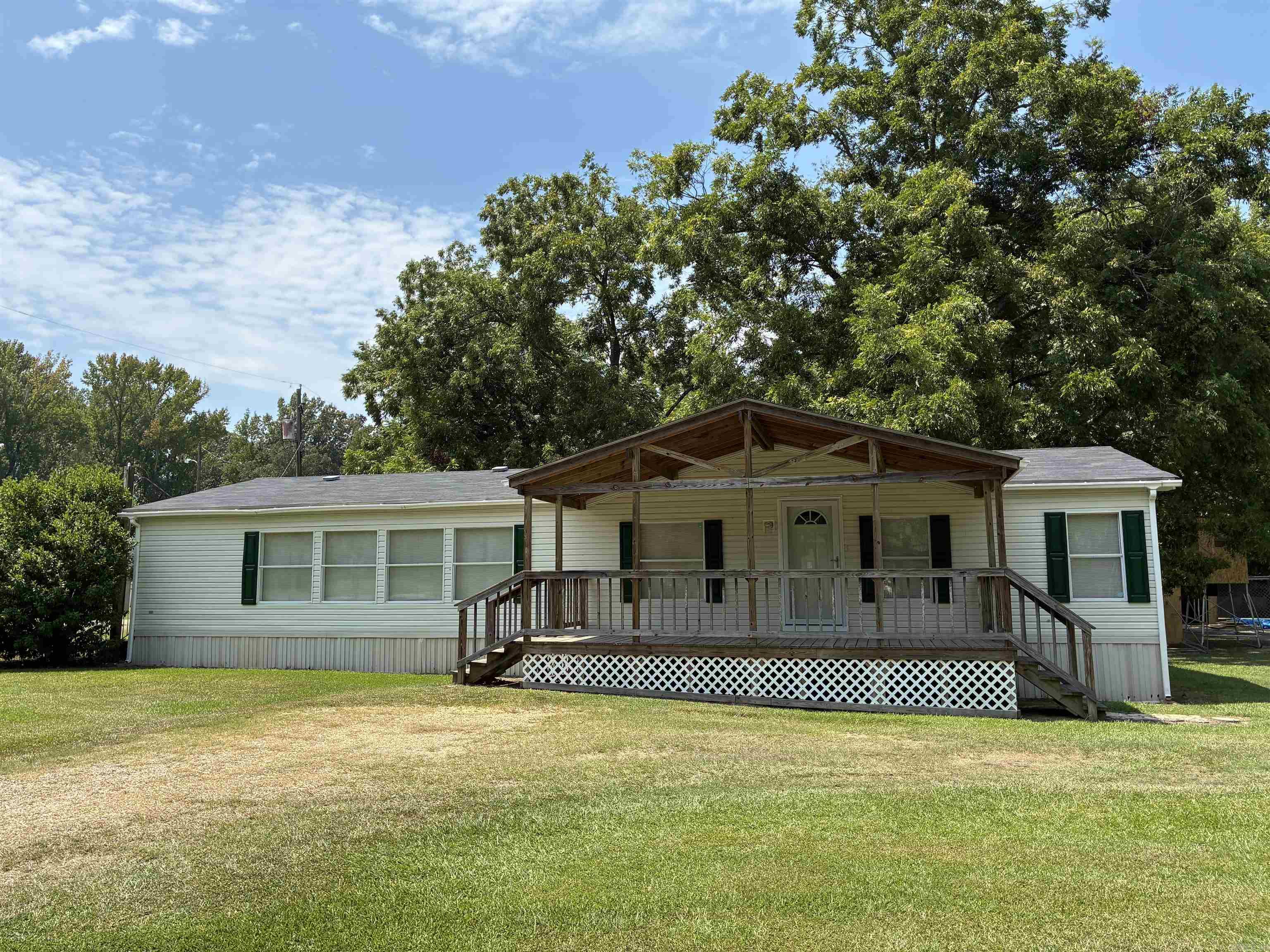 2005 1,680 sqft mobile home permanently affixed to a 0.38-acre corner lot. Immaculate condition. 3 bedroom / 2 bath, all electric. 2017 updates include paint and flooring throughout and remodeled primary bathroom. Large laundry room with side entrance. Beautiful 10x22 covered front porch. 2025 front storm door. Roof with gutters installed 2021. Original HVAC. Concrete slab patio.