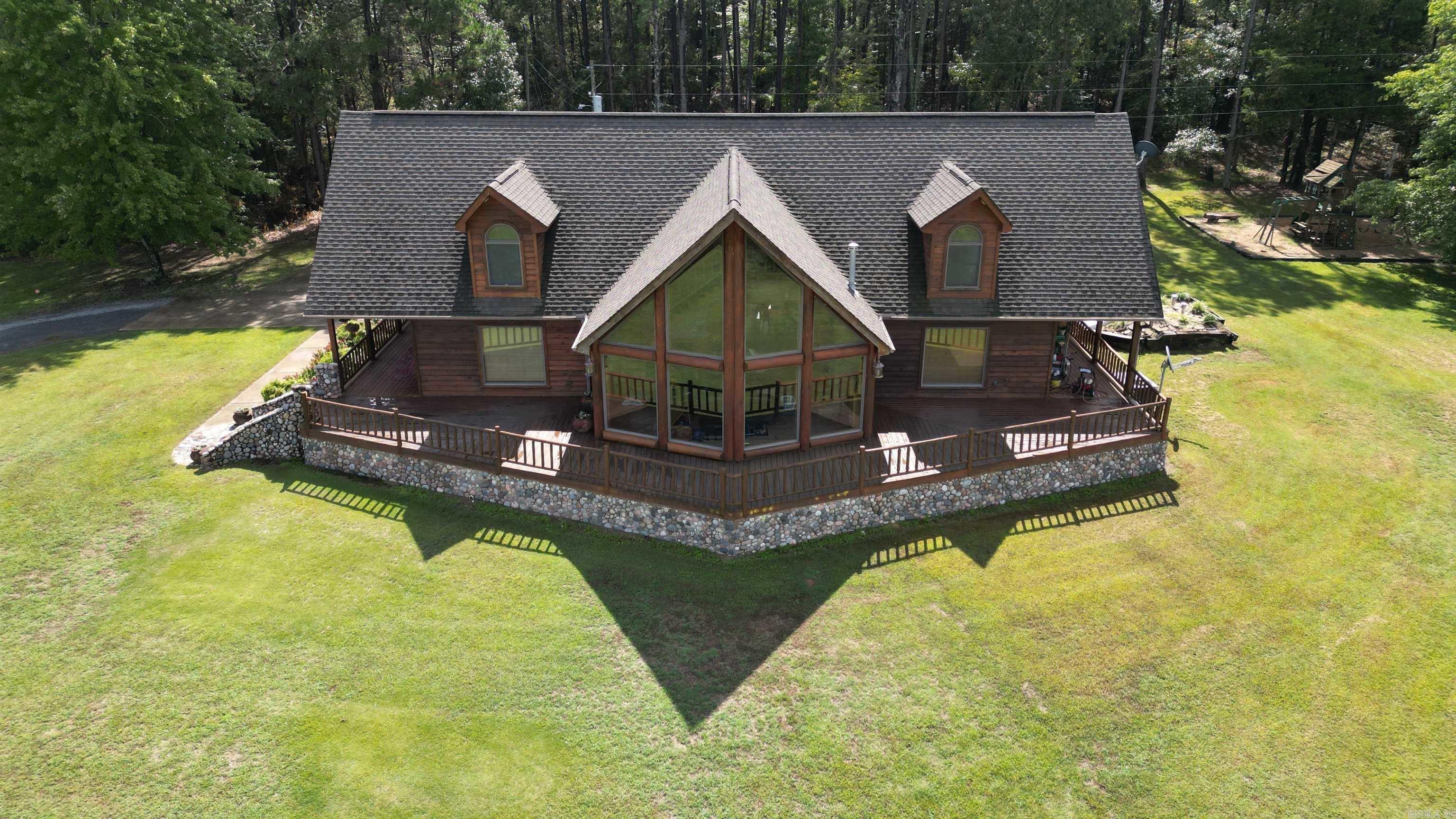 One. of. a. kind. Beautiful 4-bedroom, 3 full bad home on 13 acres with 2000 sq. feet of wrap around porches! This home features hardwood floors with vaulted ceilings and the most beautiful view from the glass windows in the living room. The kitchen and dining are open, with custom built cabinets and custom trim, allowing plenty of space for entertaining and family gatherings. The nice sized-master suite has an attached bath with a double vanity, jacuzzi and marble flooring. This home features an open loft area for office space or game room, flowing into two bedrooms and a full bath upstairs. The home is equipped with Anderson doors and windows! There is also a 3-acre pond stocked with bass! Must see in person!
