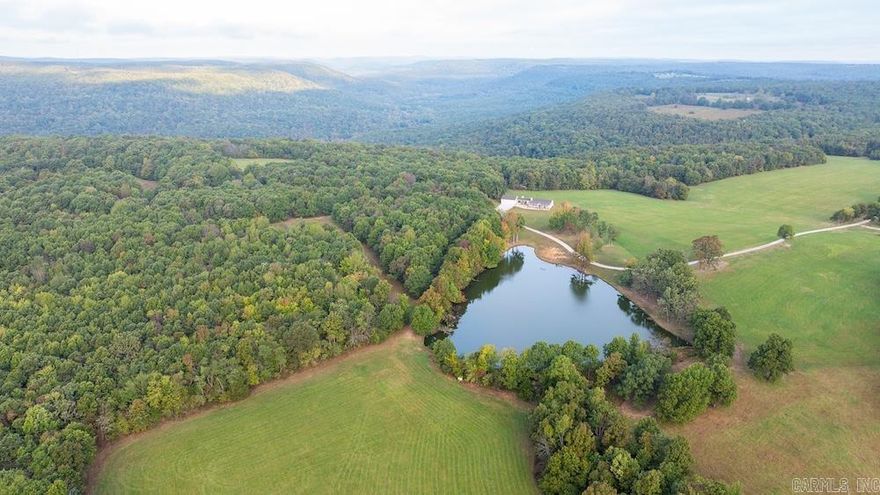 "Nothing left to be desired" perfectly describes this world-class recreational ranch. From the moment you enter off the county road, you are greeted with multiple access points, fencing, and end-of-the-road privacy. The newly built 2,700 sq ft custom home offers comfort and function, along with a detached oversized garage and a charming 900 sq ft farmhouse ideal for guests or a hunting camp. Manicured grounds, a gated entrance, and rural water add to its appeal. A 30x50 shop with concrete floors and 220 electric service sits near the main entrance. The ranch features open ridge tops, lush hay meadows, food plots, ponds, and a spring-fed three-acre lake with aerators, a fountain, and 1,500 feet of shoreline. Trails wind through pristine hardwood forest leading to Osage Creek, which flows 3.5 miles through the property with springs, hay fields, and a seasonal waterfall. Wildlife abounds with trophy whitetail deer, turkey, bear, and elk. This is a true outdoor paradise just 25 minutes from the Buffalo National River.