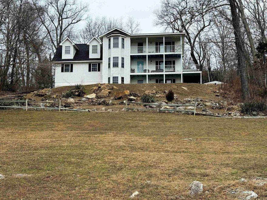 Enjoy year-round panoramic views from this stunning White River home. The property features two master suites, each with a private balcony, plus an additional sitting room ideal for relaxing or entertaining. The spacious kitchen offers glass-front cabinetry, abundant storage, and a large walk-in pantry. A walkout basement with a striking spiral staircase adds architectural charm and functionality. Outdoor living shines with a covered wrap-around deck overlooking the river. Comfort is ensured year-round with zoned HVAC and an outdoor wood furnace. Situated on a riverfront lot with direct views of the White River and a boat launch located directly in front of the home, this property is a dream for outdoor enthusiasts. Located in a prime fishing and hunting area and just 30 minutes from Bull Shoals Lake State Park, also offering camping, fishing, and hiking trails.