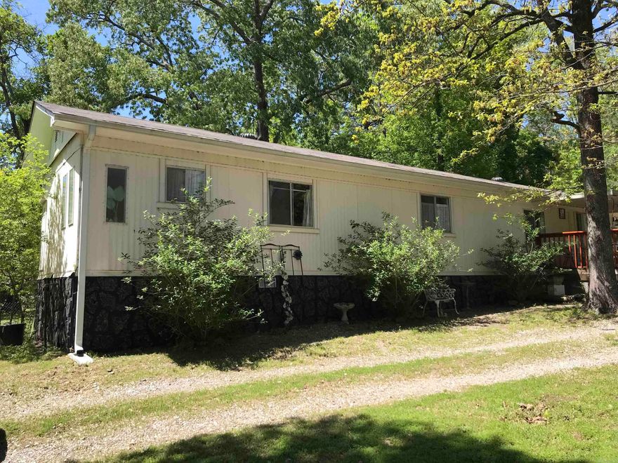 Great location, just off Airport Road and Lakeshore Drive. 14' x 66' Mobile home.   Recent improvements include new roof in 2023, new HVAC 2024, New gas over range 2022. Electric & dryer 2020. Nice decks, both front and rear. Detached single carport. Small fenced in area around home with a pet door. Location fairly close to Lake Hamilton and Hill Wheatley Park with boat ramp. Large outside storage building, and kitchen refrigerator do not stay.